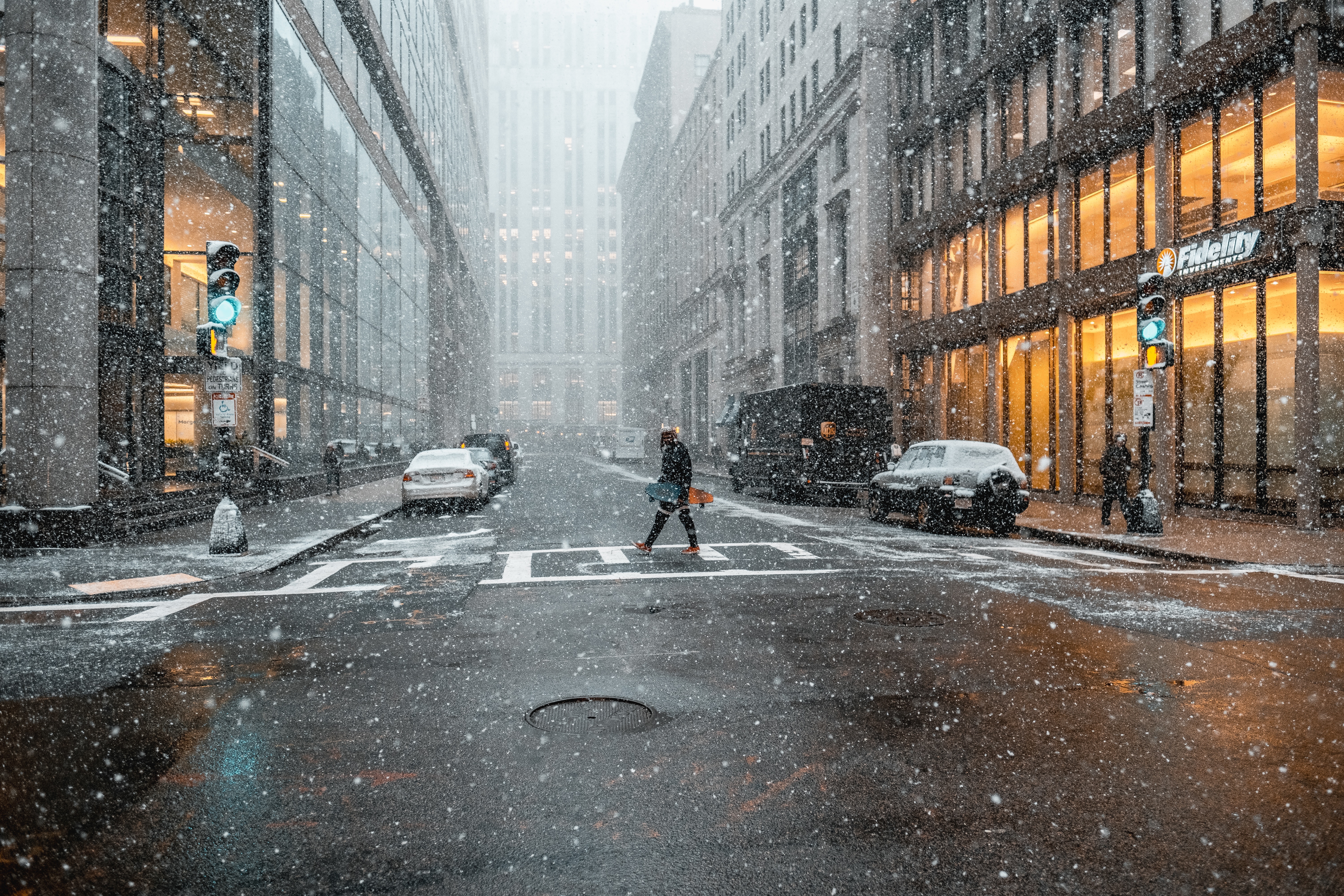 Person crossing a snowy street in Boston HD Wallpaper