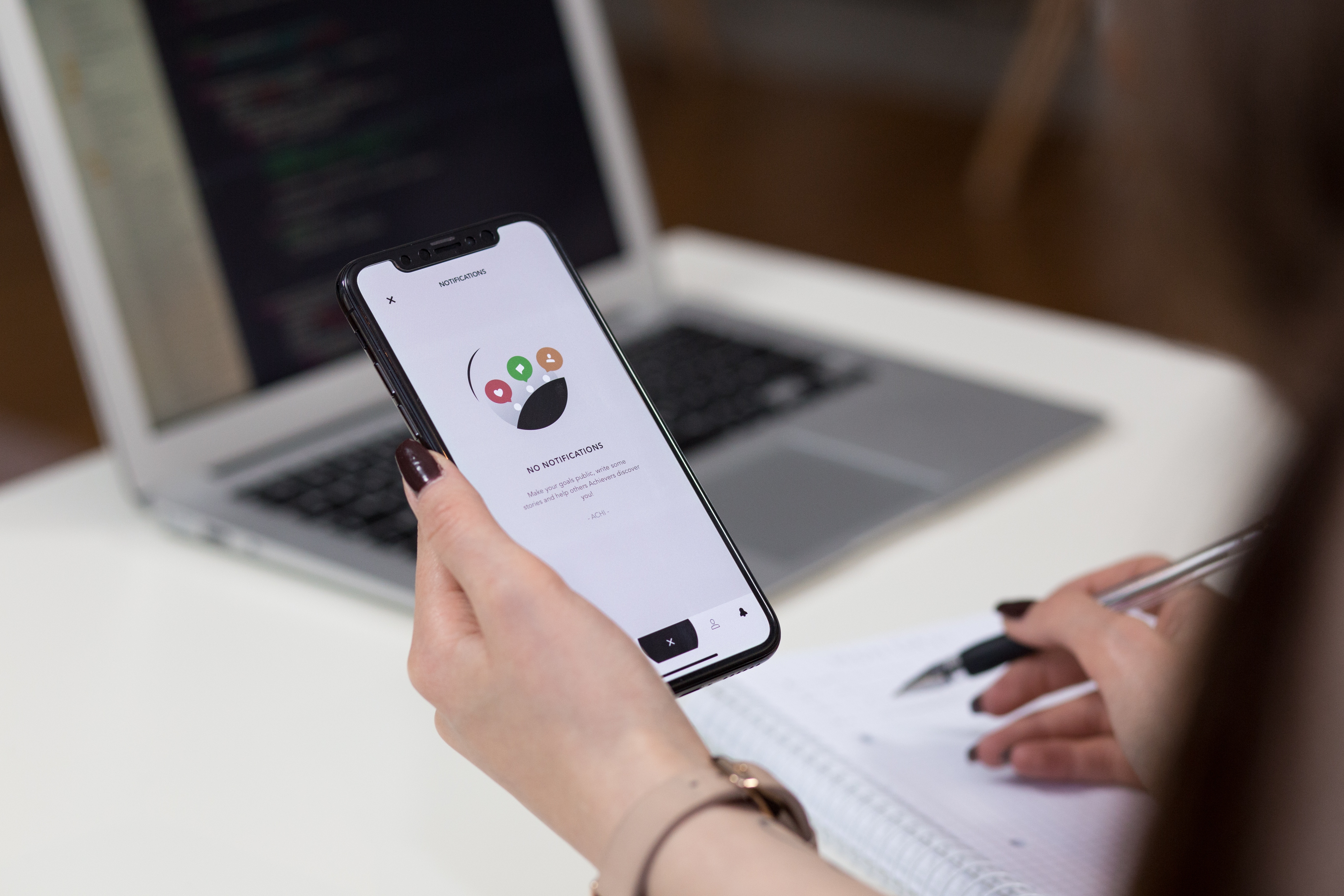 Woman holding iPhone X with 'No Notifications' app screen HD Wallpaper