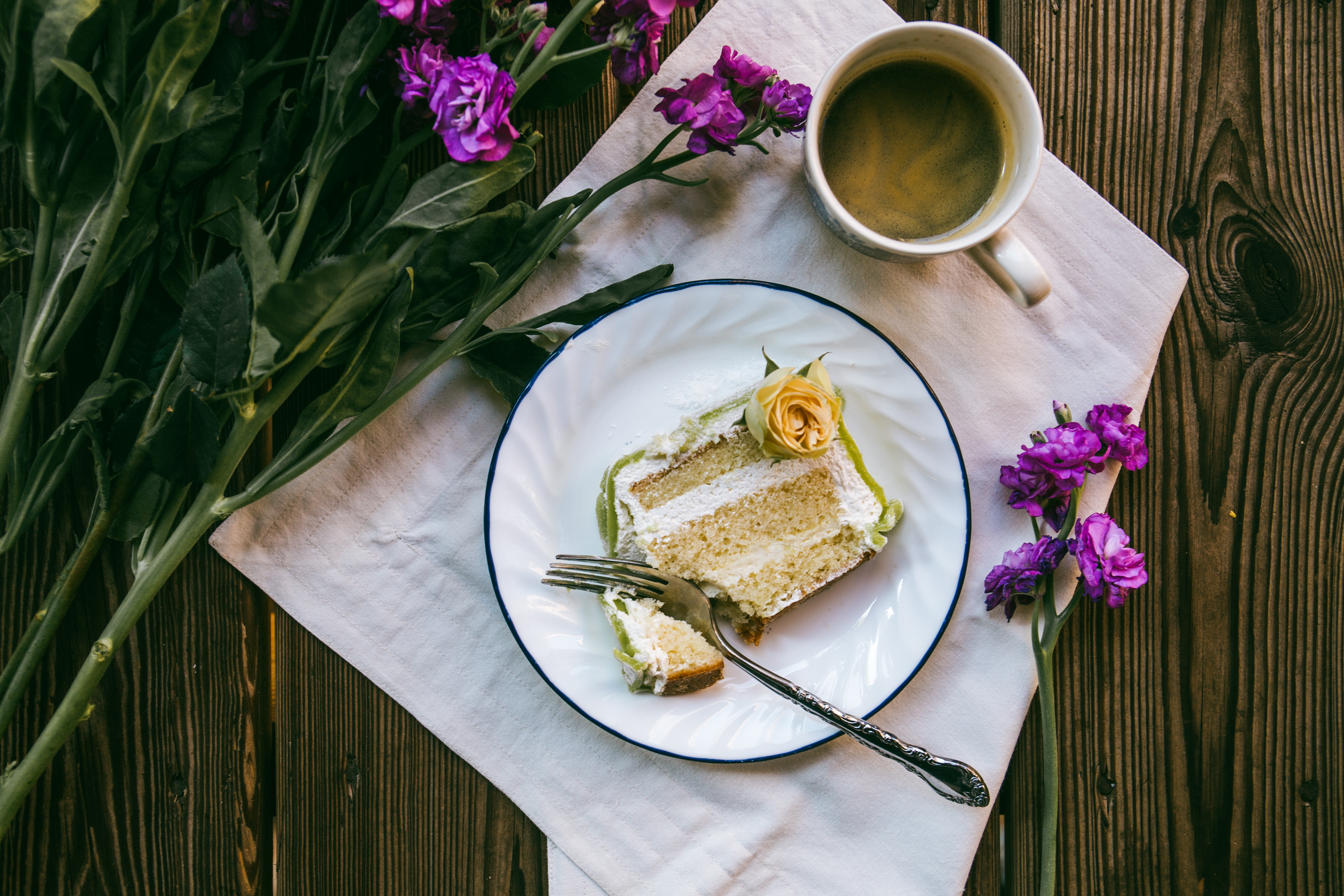 Slice of cake with coffee and flowers on a wooden table HD Wallpaper