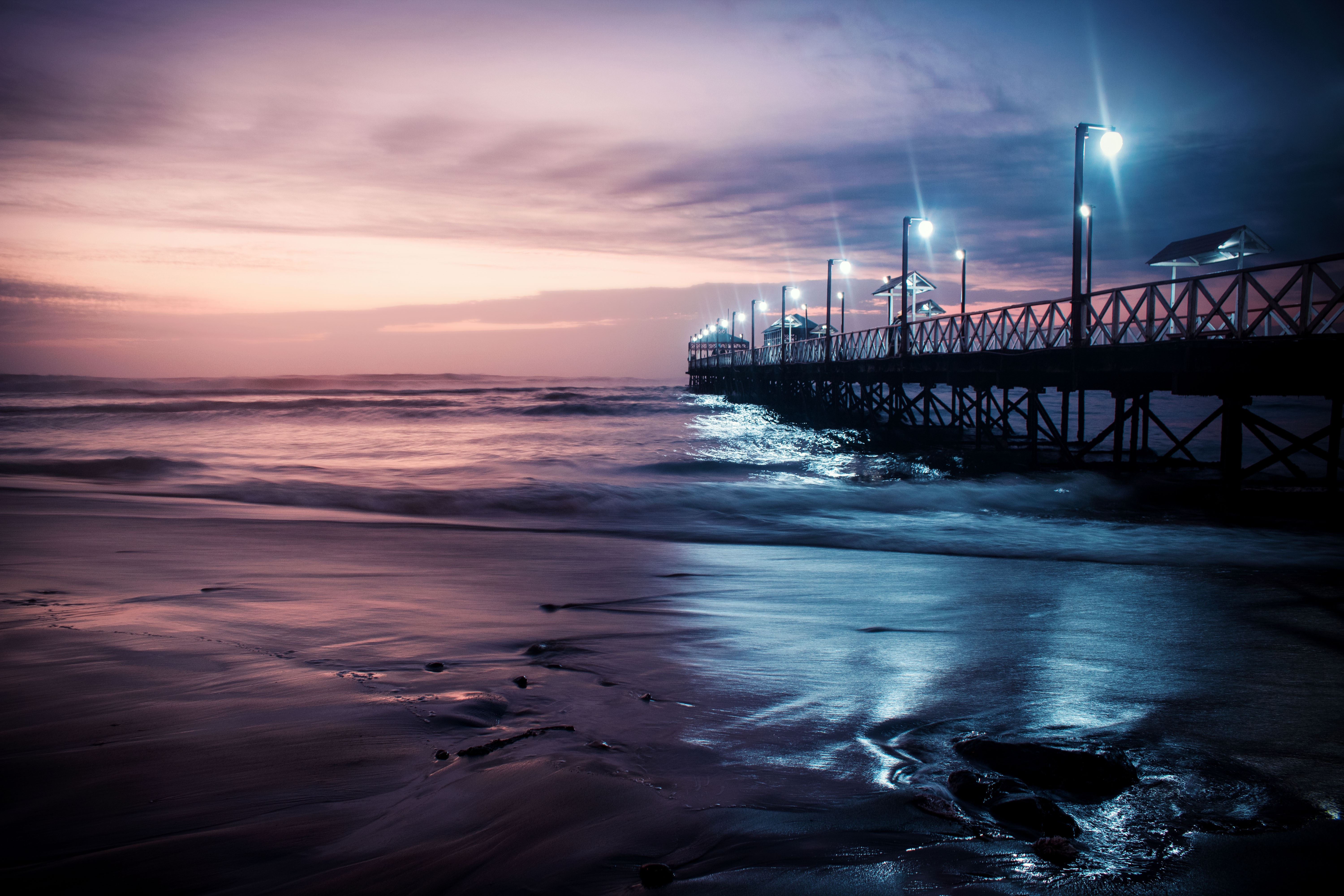 Pier with lights over the ocean at dusk HD Wallpaper