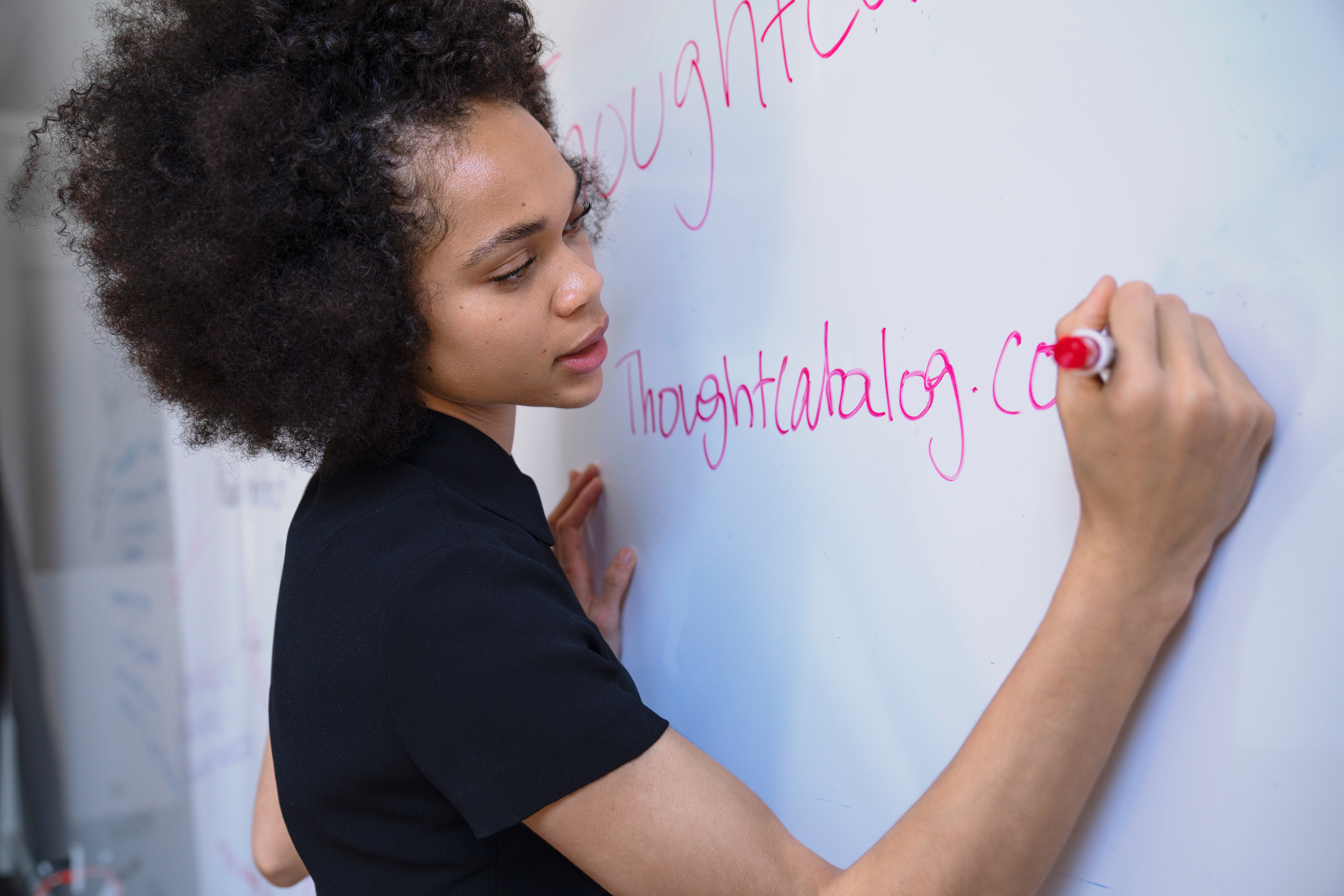 Woman writing "thoughtcatalog.com" on a whiteboard HD Wallpaper