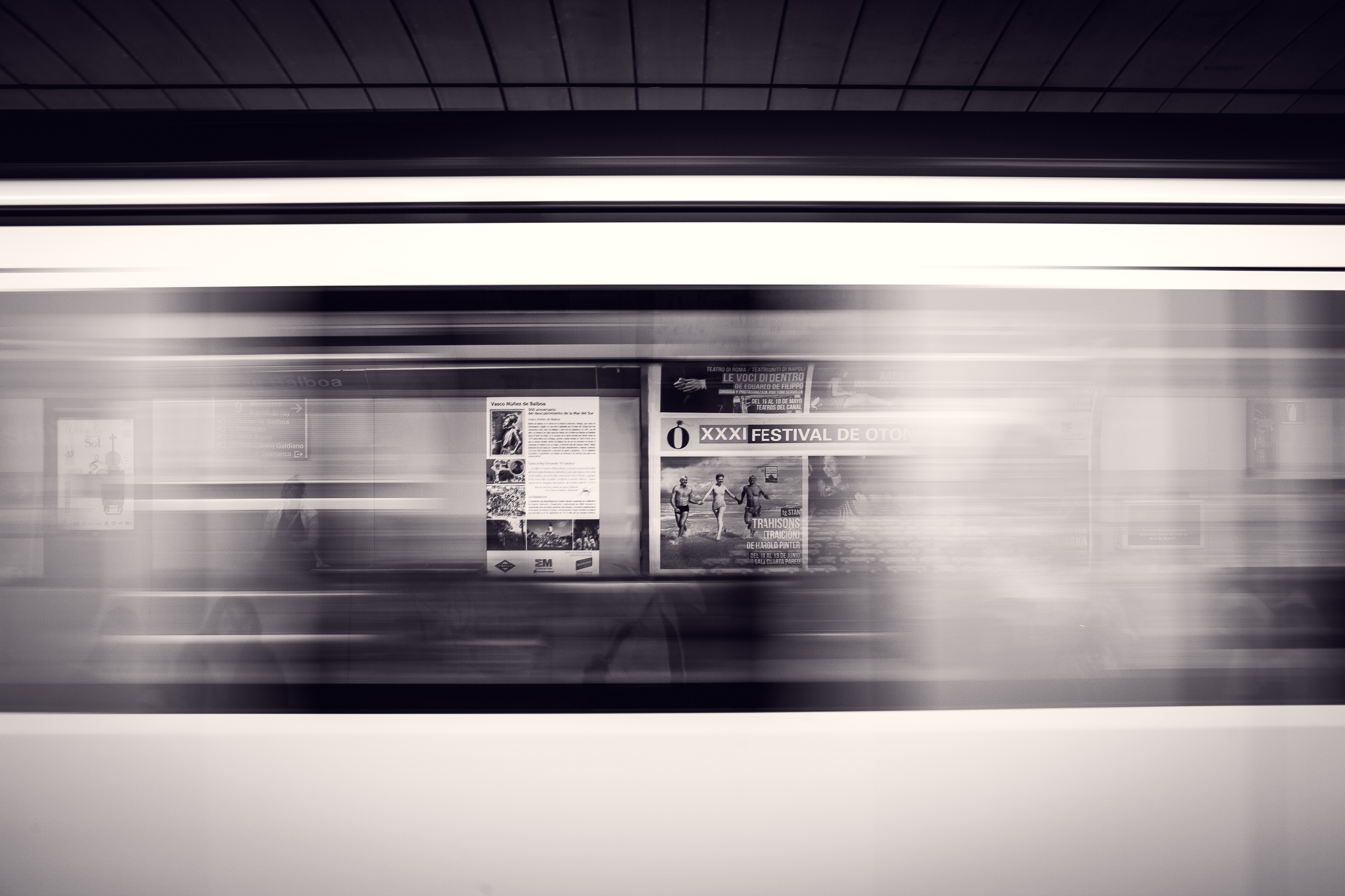 Blurred train window with posters in monochrome HD Wallpaper