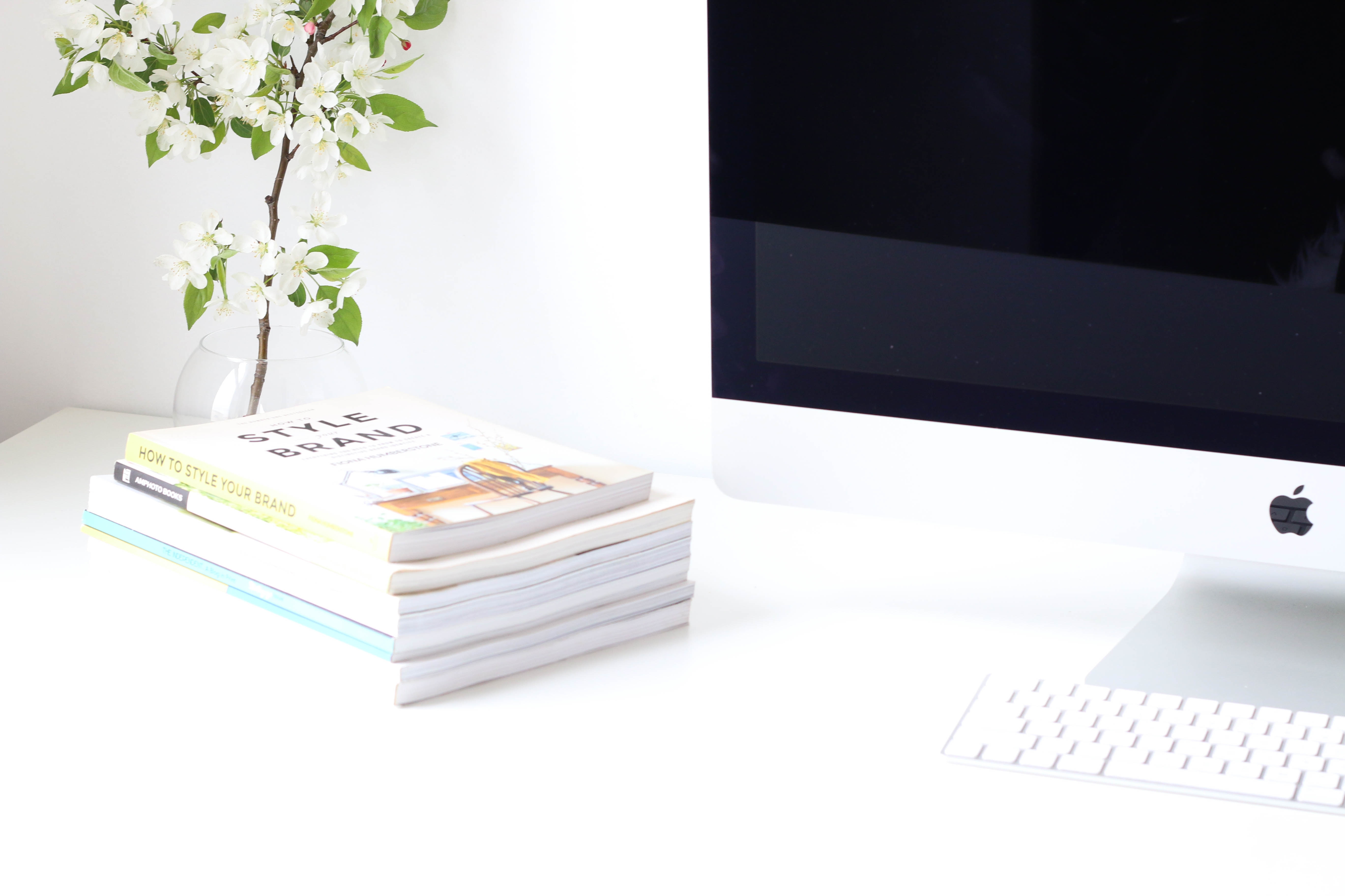 Apple iMac computer with books and flowers on a desk HD Wallpaper