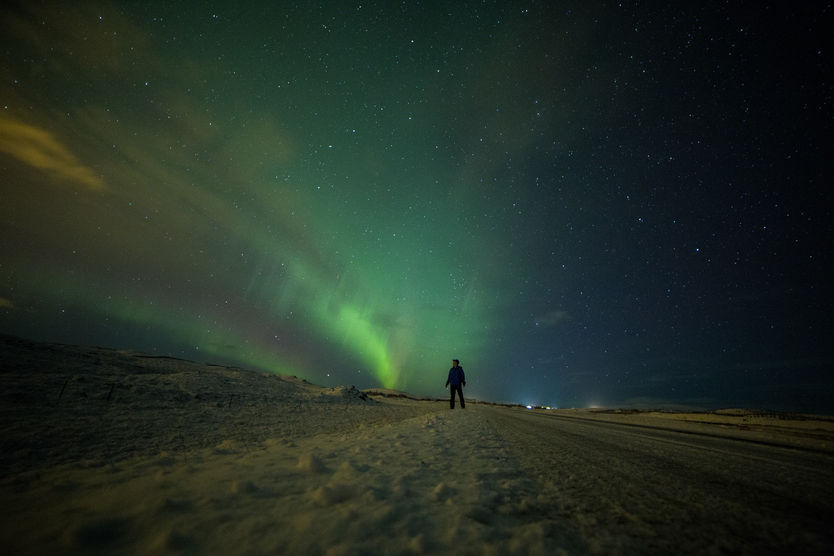 Man watching Aurora Borealis in Iceland HD Wallpaper
