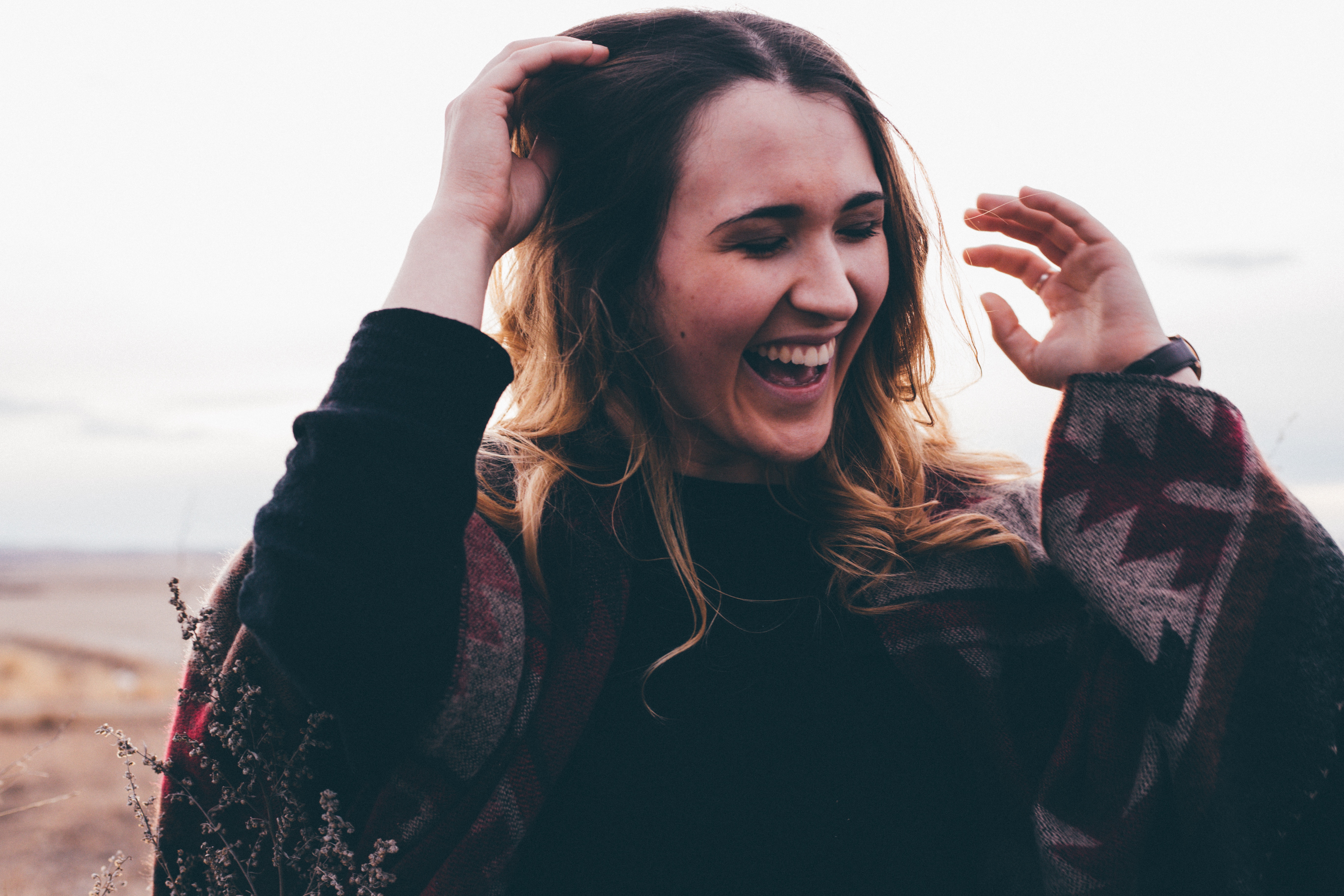 Young woman laughing outdoors HD Wallpaper
