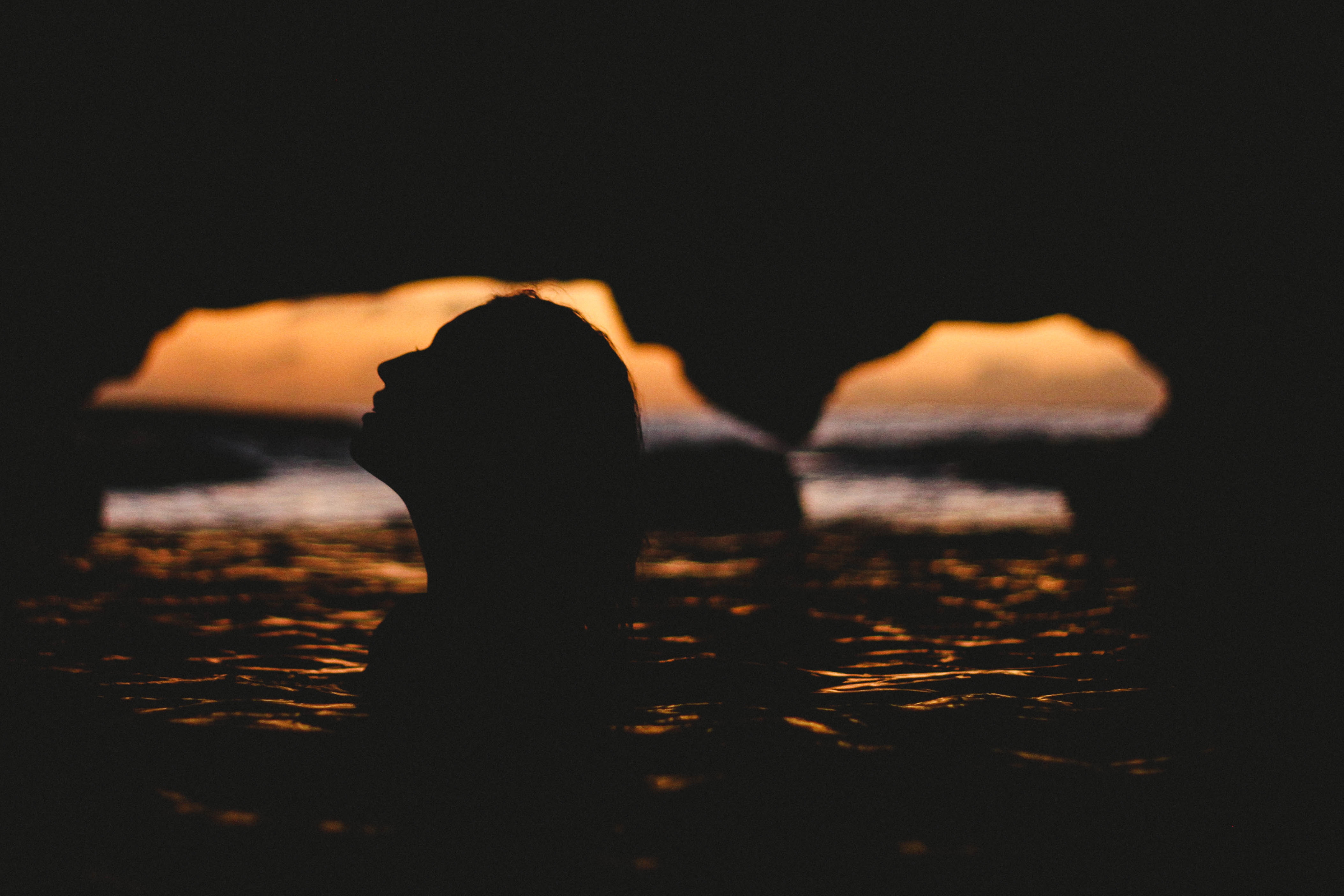 Silhouette of a woman in water at sunset HD Wallpaper