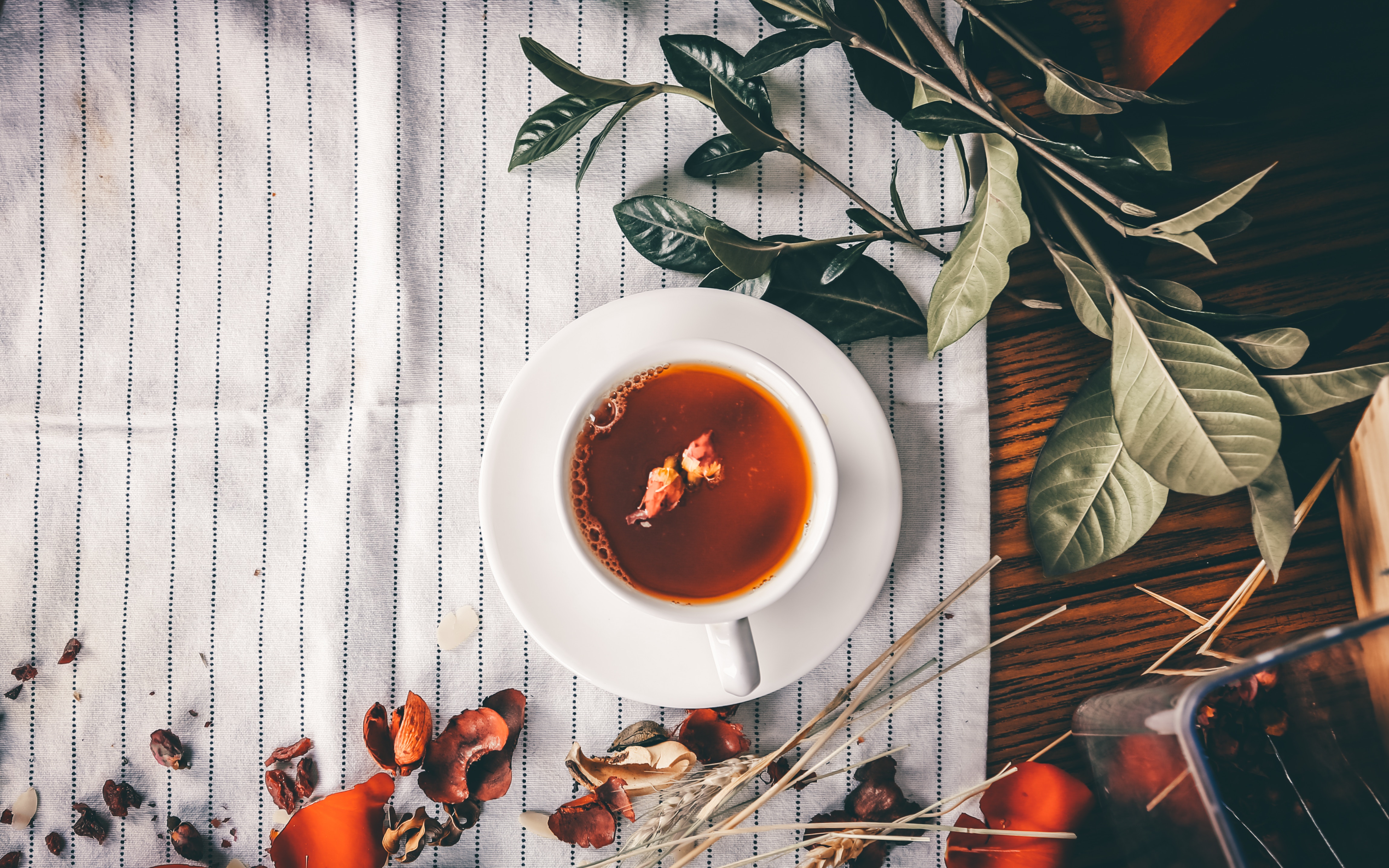 Rose tea in a cup on a striped cloth with leaves HD Wallpaper