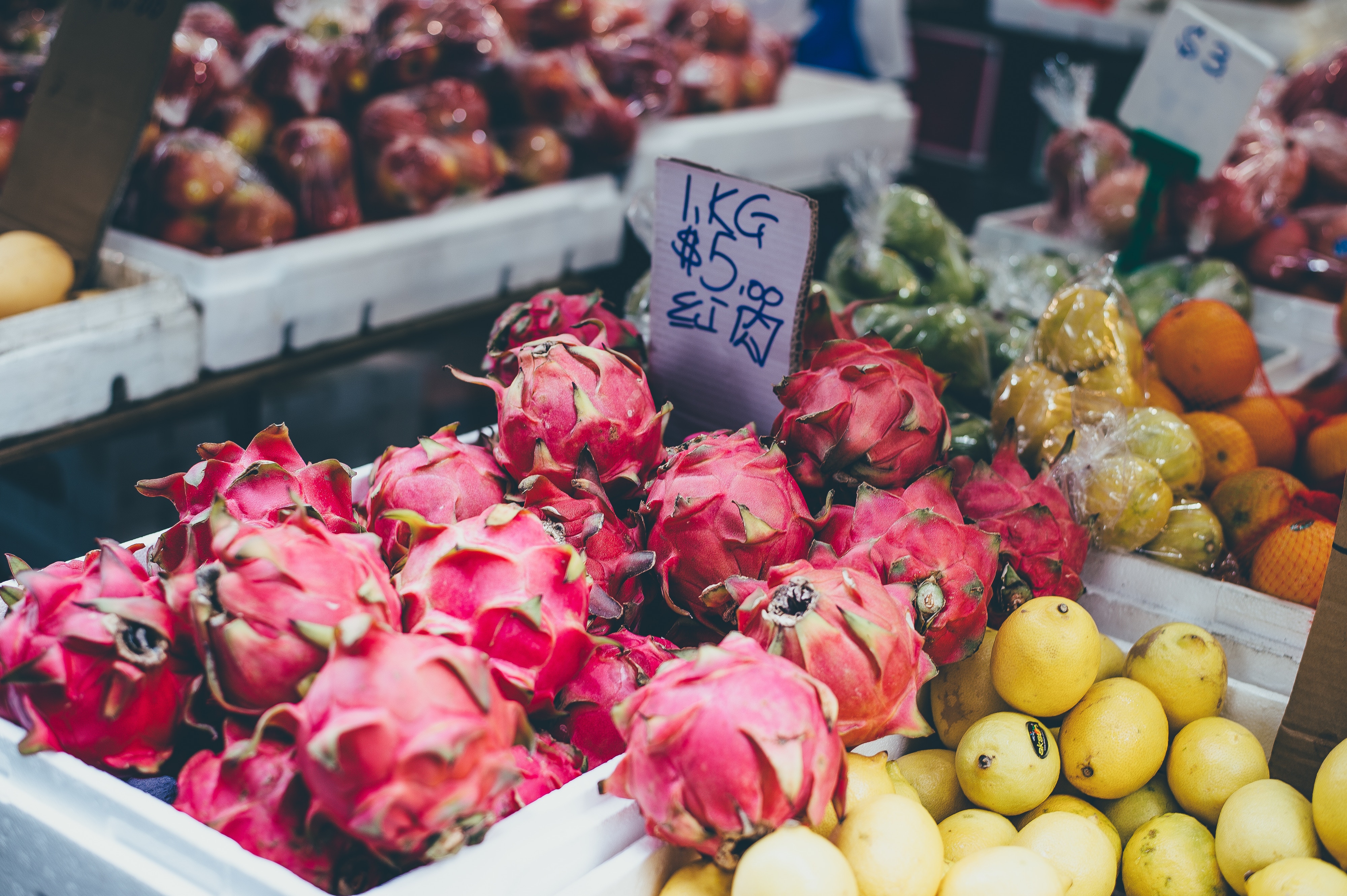 Dragon fruit and lemons at a market stall HD Wallpaper