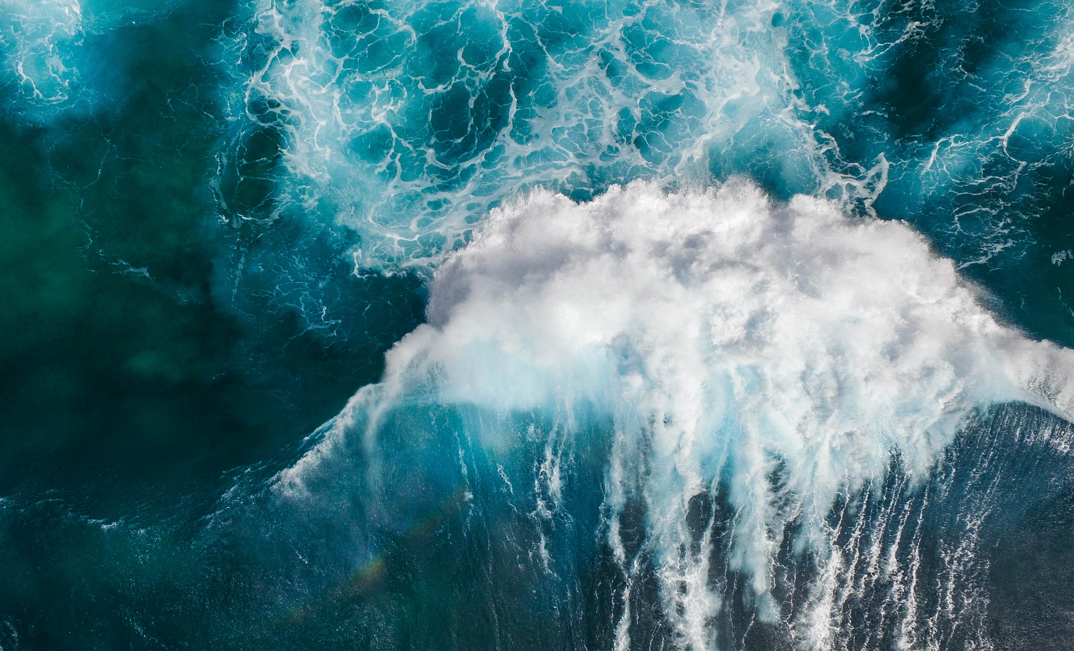 Aerial view of a powerful ocean wave crashing HD Wallpaper