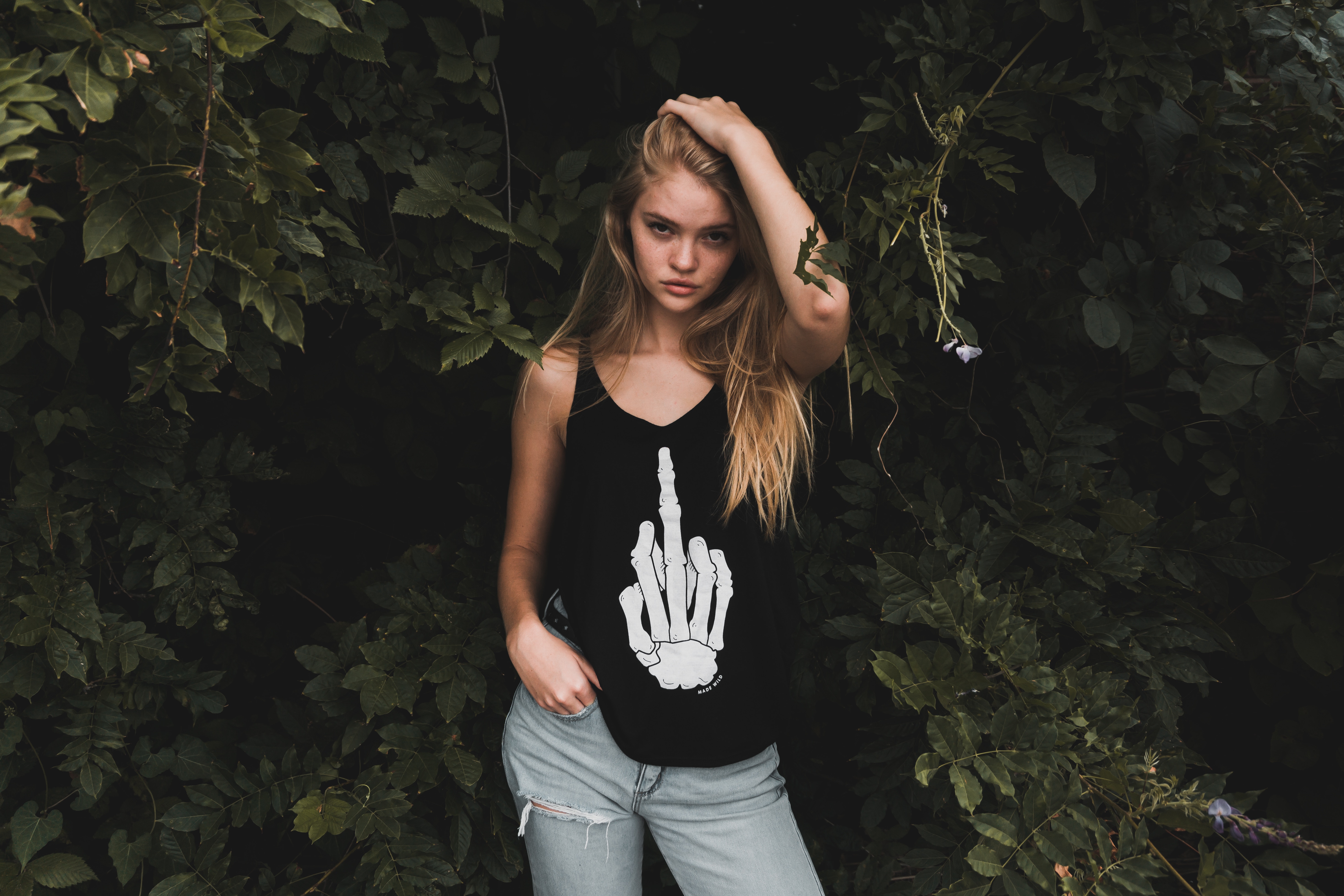Woman in tank top and ripped jeans posing outdoors HD Wallpaper