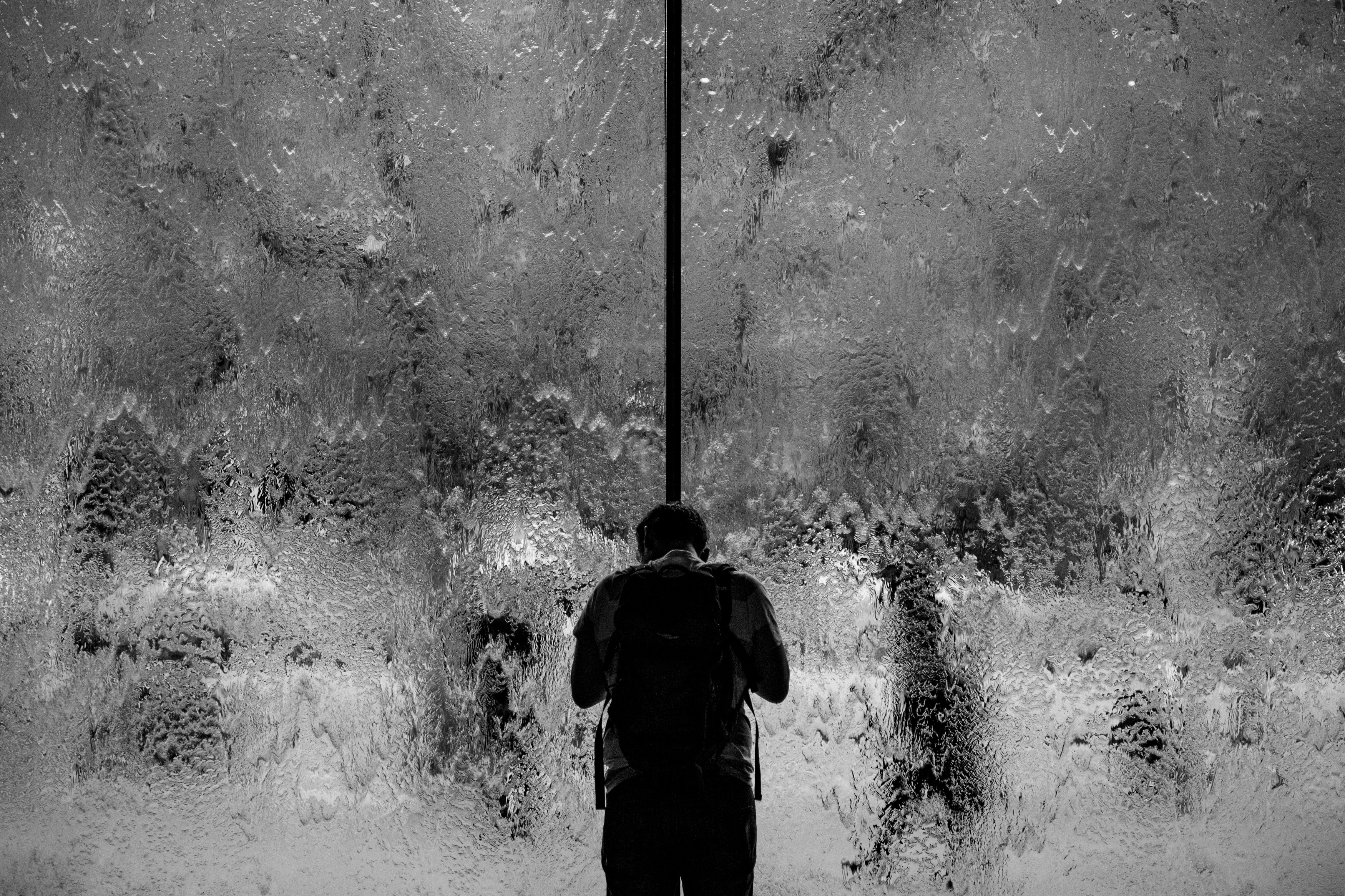 Man with backpack looking at a waterfall HD Wallpaper