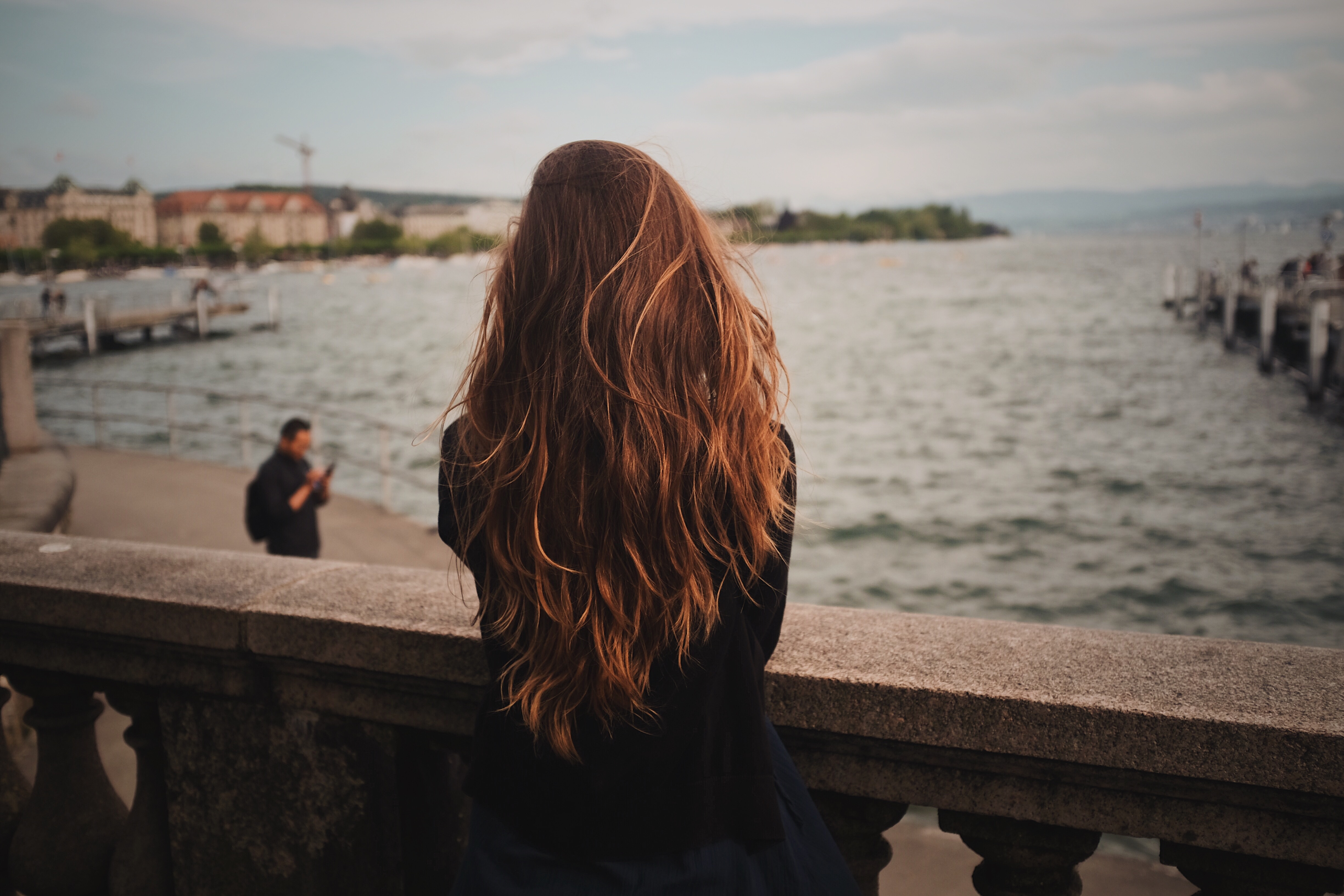 Woman with long hair looking at Lake Zurich HD Wallpaper