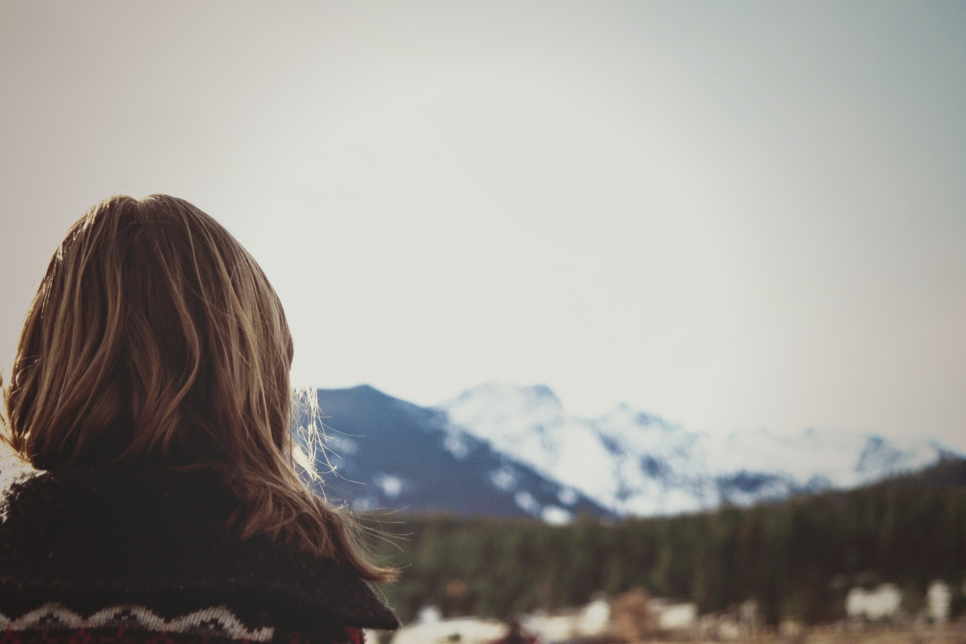 Girl looking at snow-capped mountains and forest HD Wallpaper