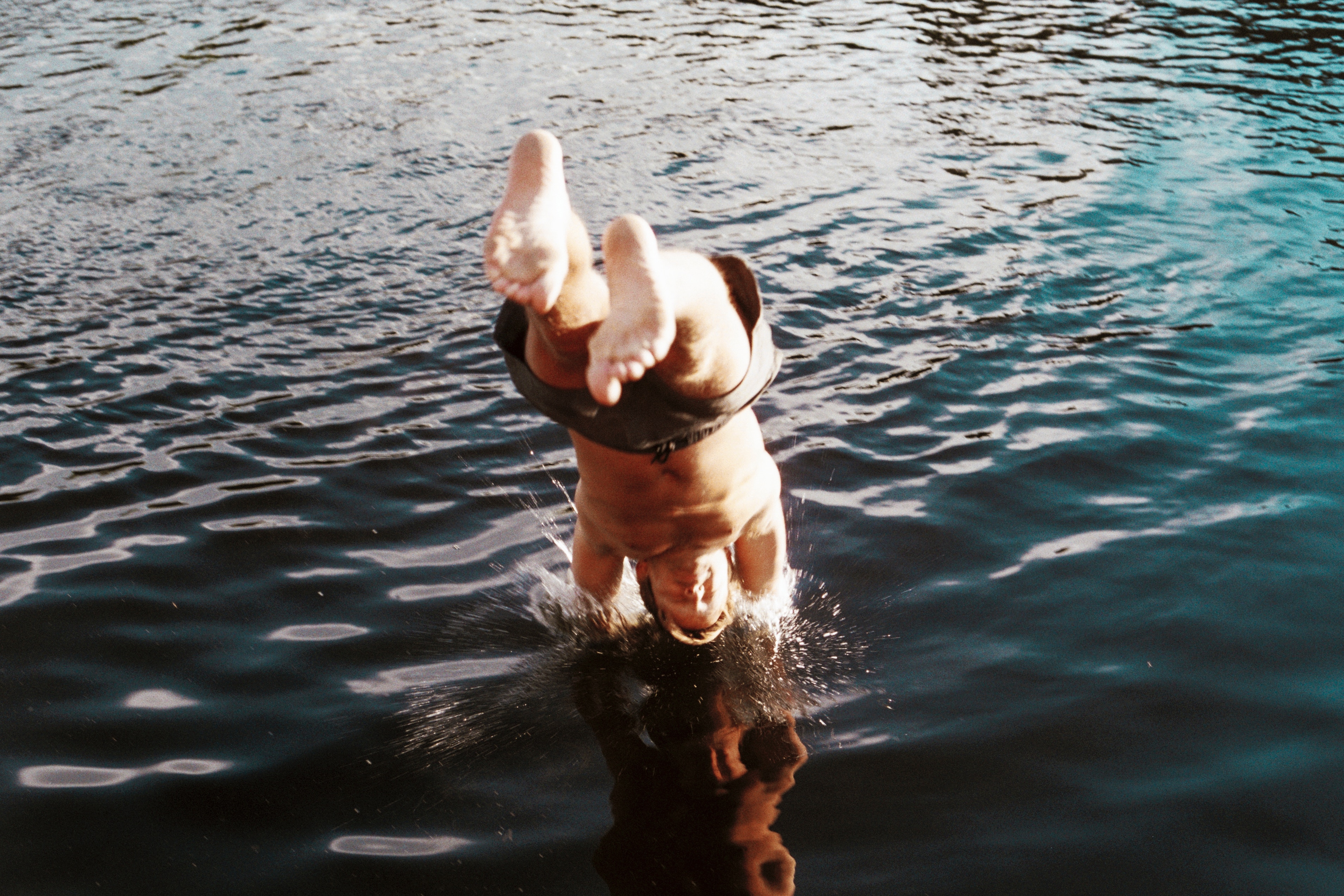 A person dives into a lake, creating a splash HD Wallpaper