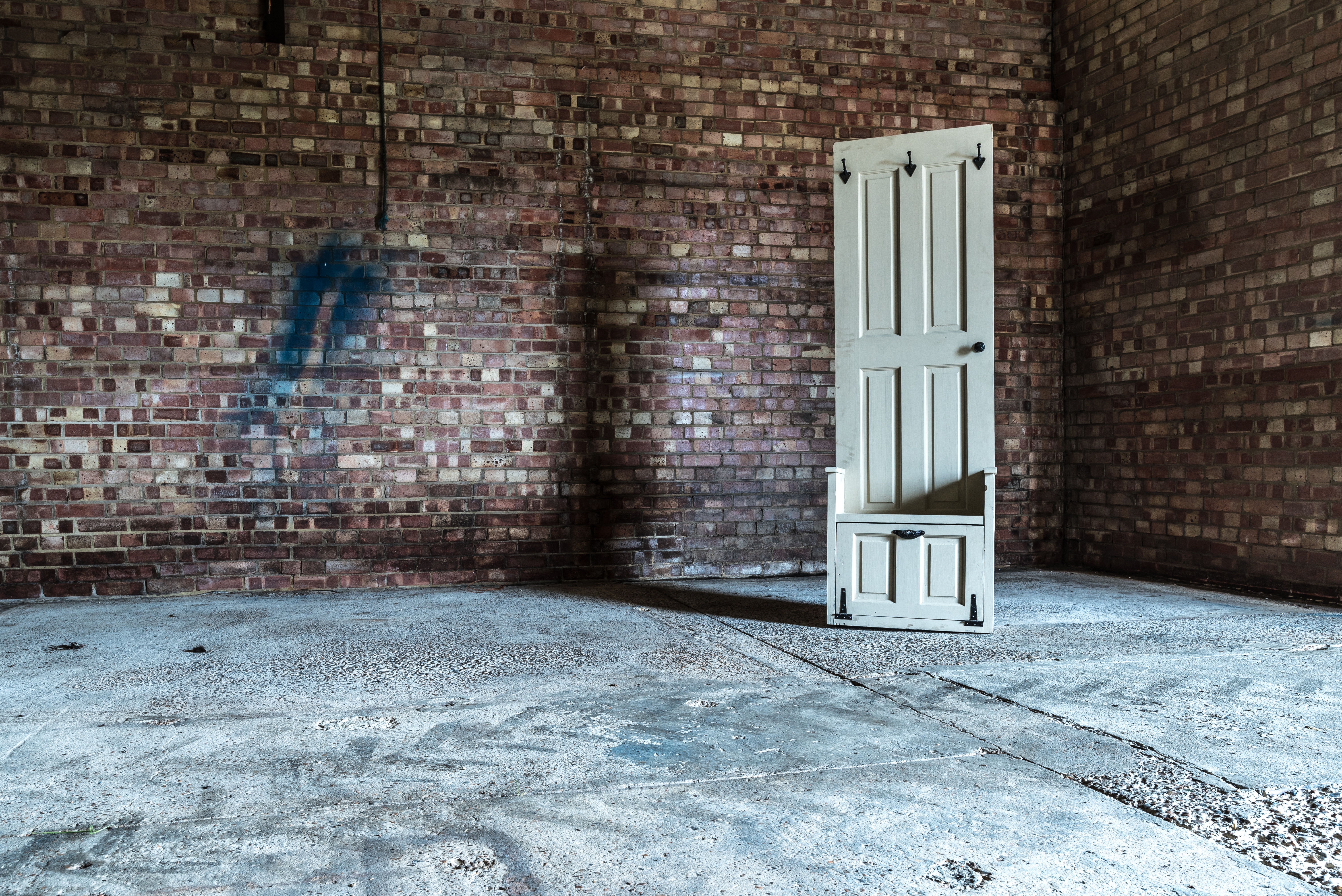 Reclaimed door repurposed as a chair in an empty warehouse HD Wallpaper