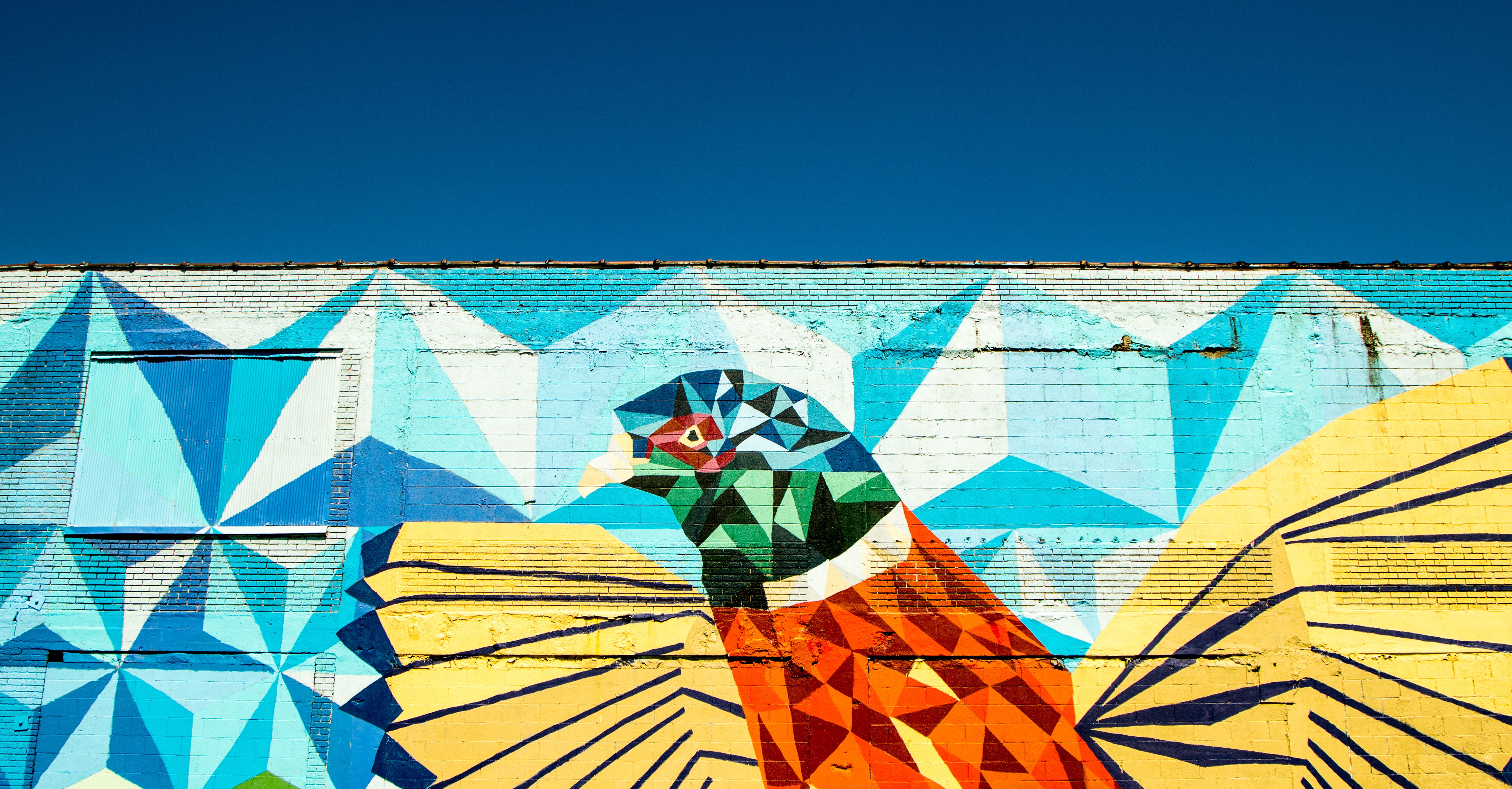 Mural of a geometric bird on a brick wall in Detroit HD Wallpaper