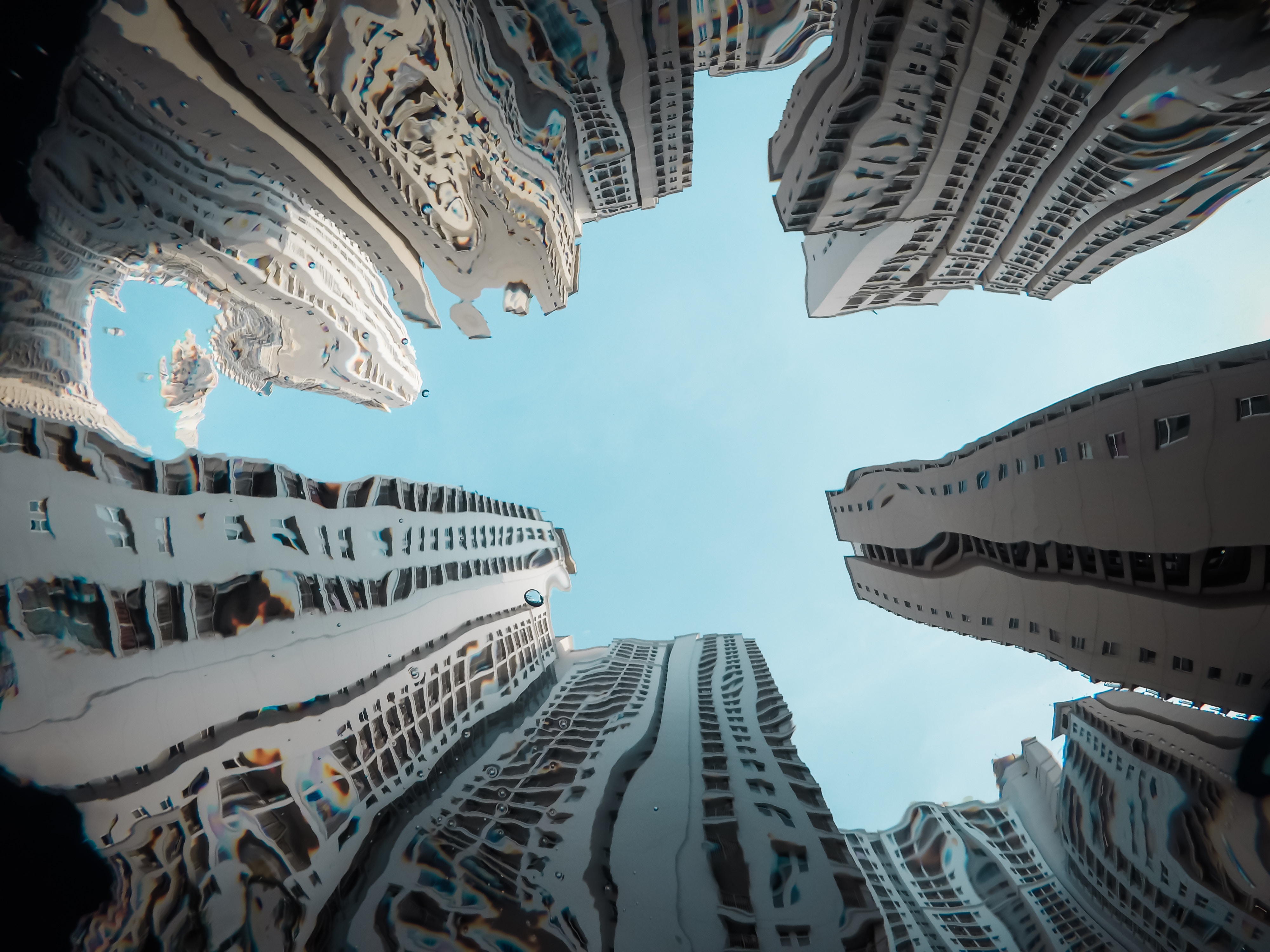 Skyscrapers reflected in water under blue sky HD Wallpaper