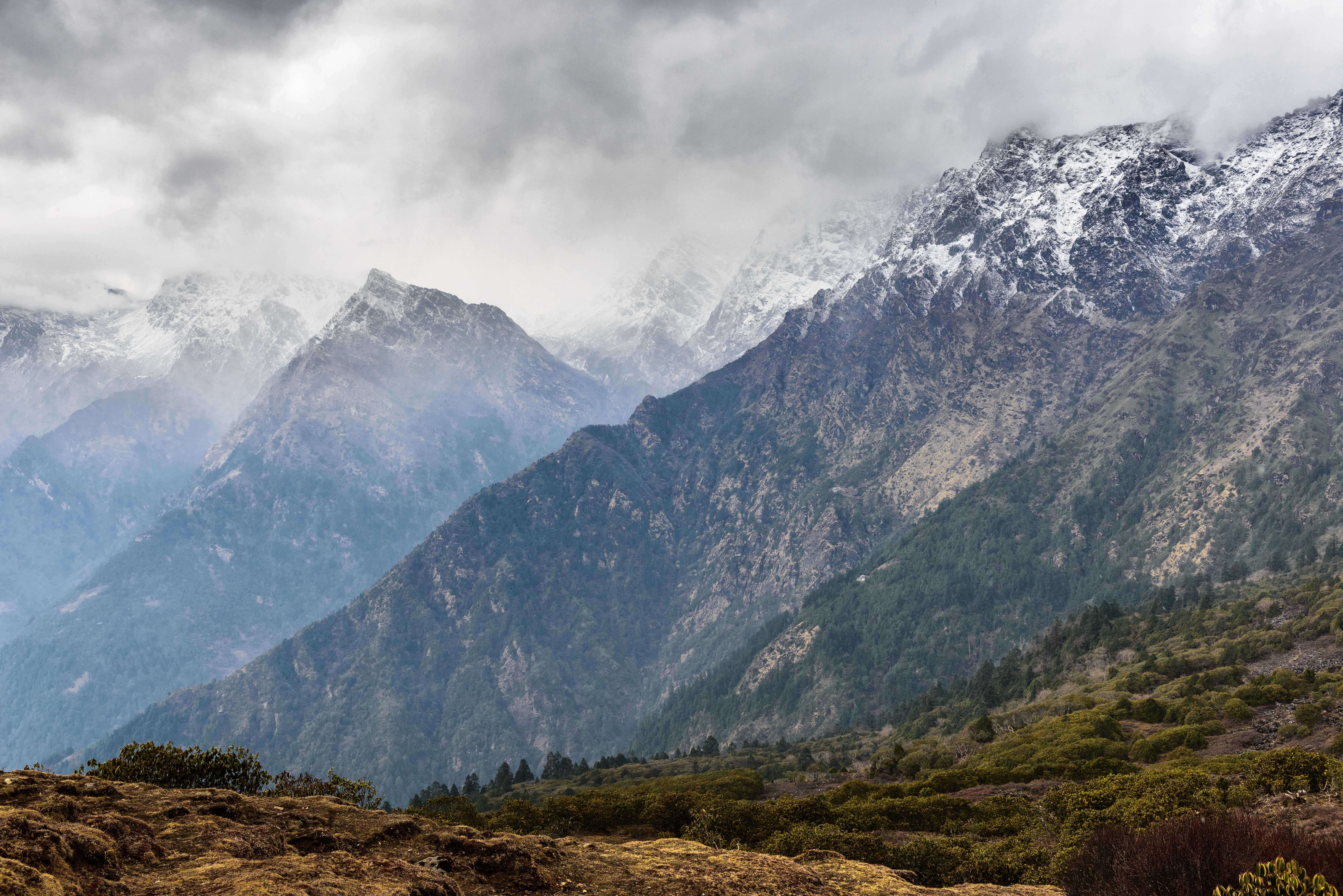 Snow-capped mountains in Langtang, Nepal under cloudy skies HD Wallpaper