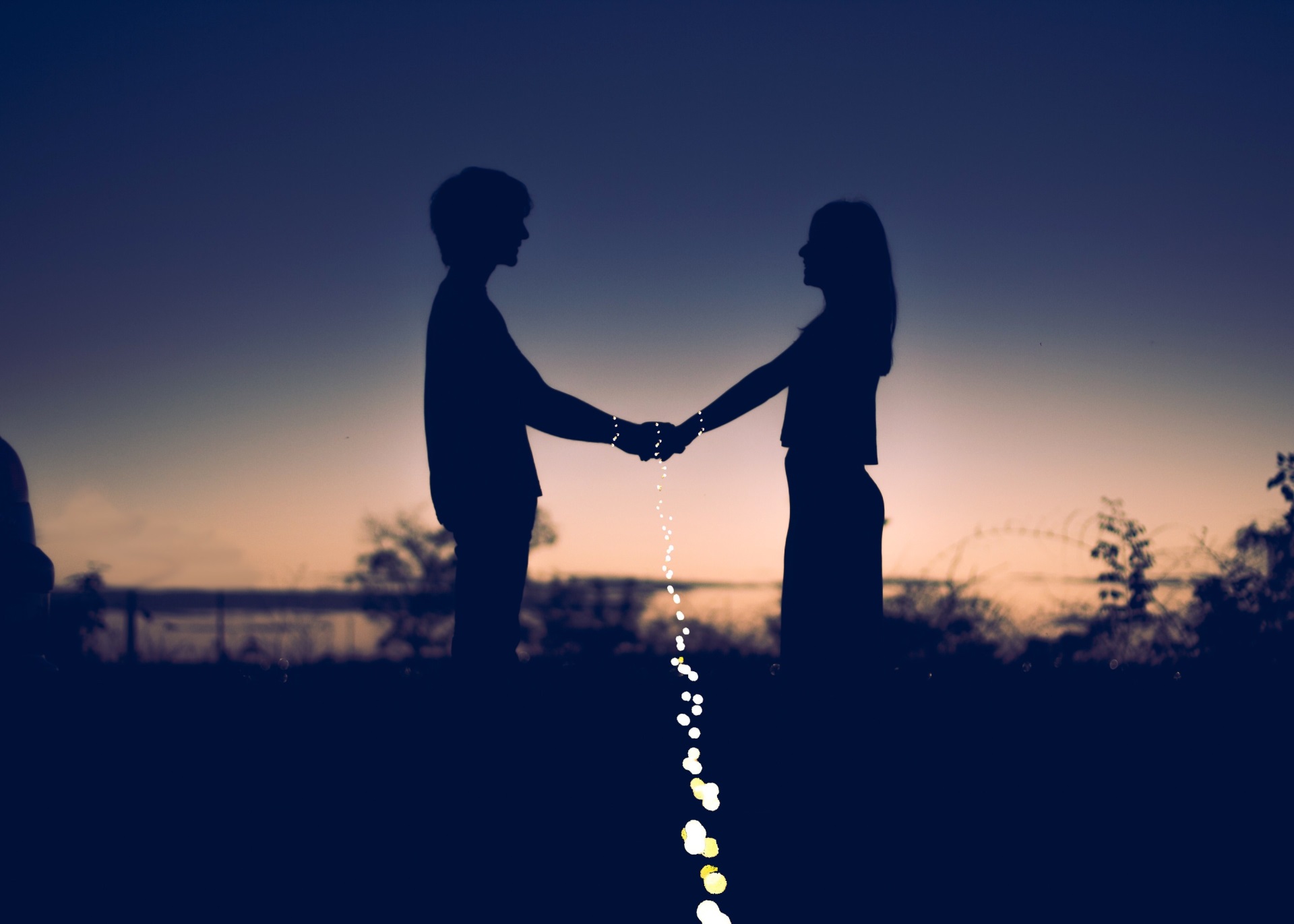 Silhouettes of a couple holding hands at sunset HD Wallpaper