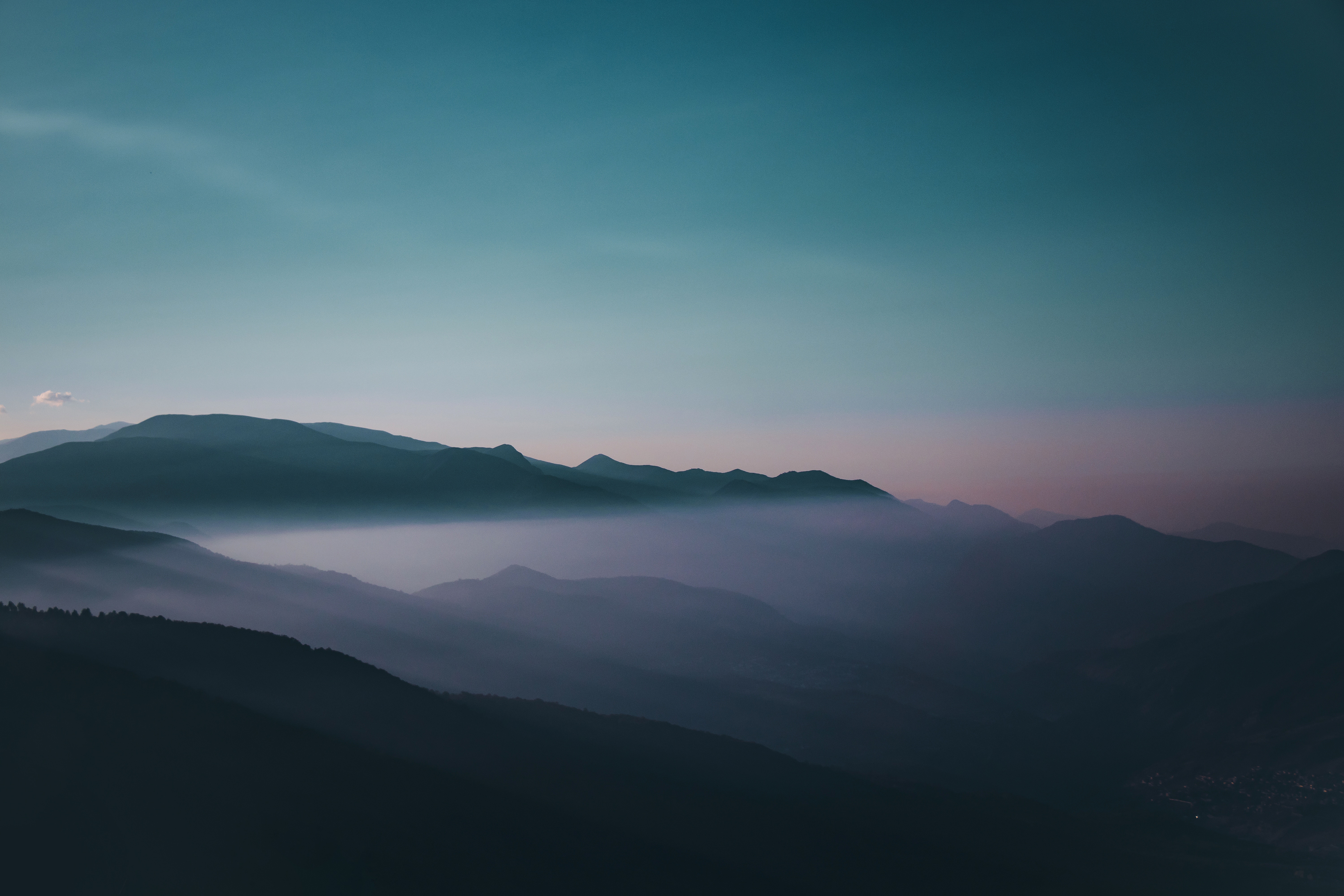 Layered mountains shrouded in mist at sunset HD Wallpaper