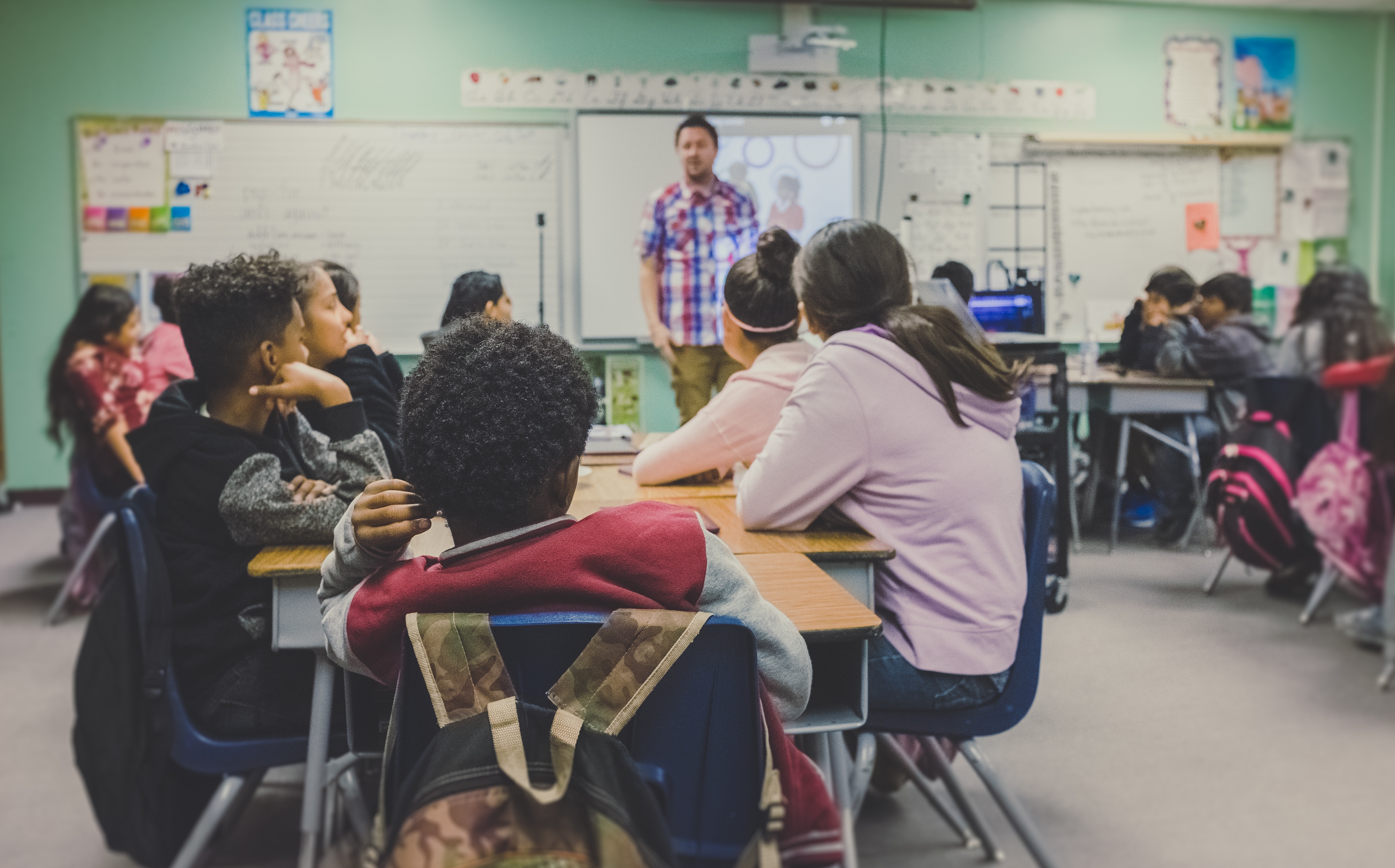 Teacher instructing students in a classroom HD Wallpaper
