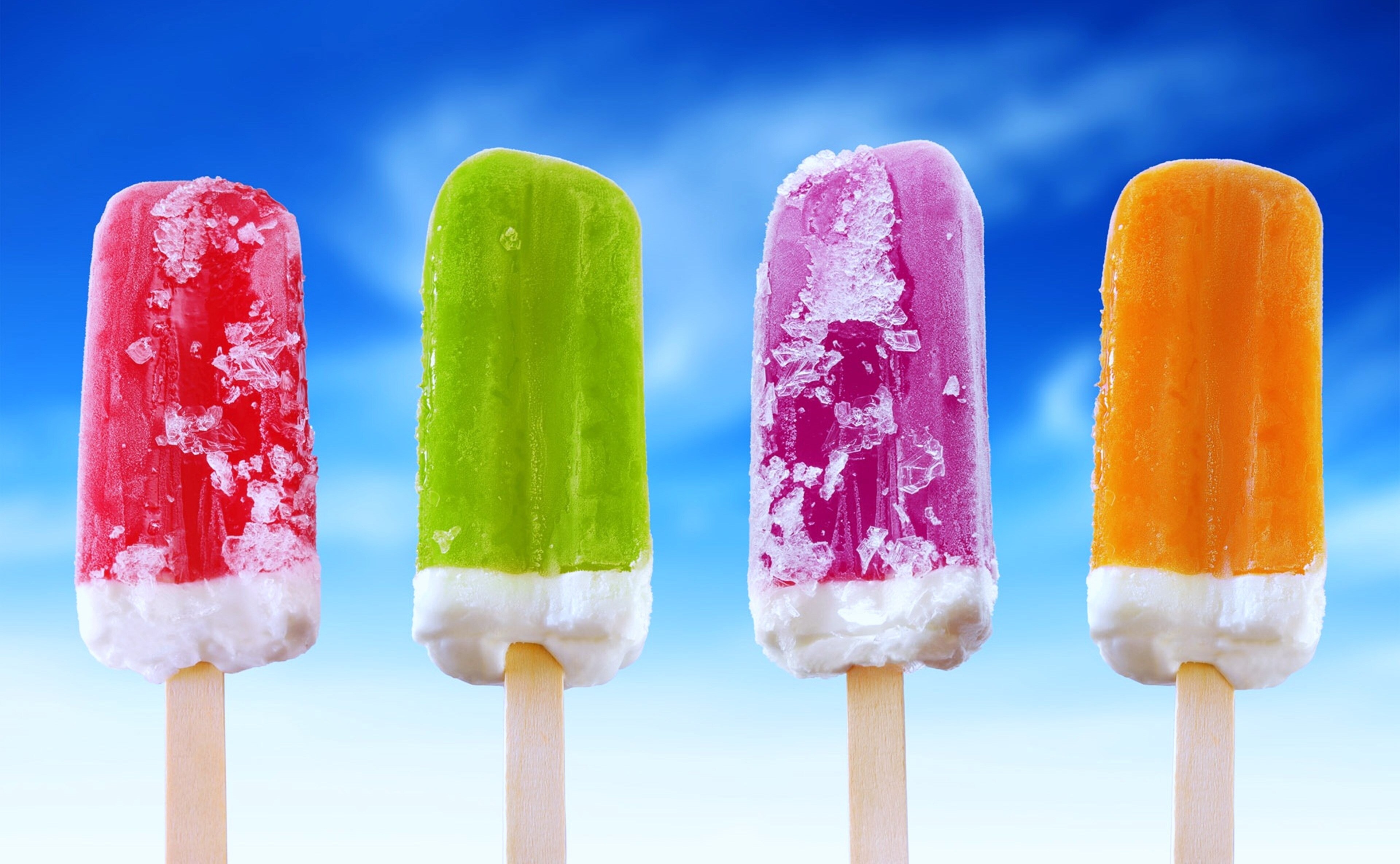 Four colorful popsicles on sticks against a blue sky HD Wallpaper