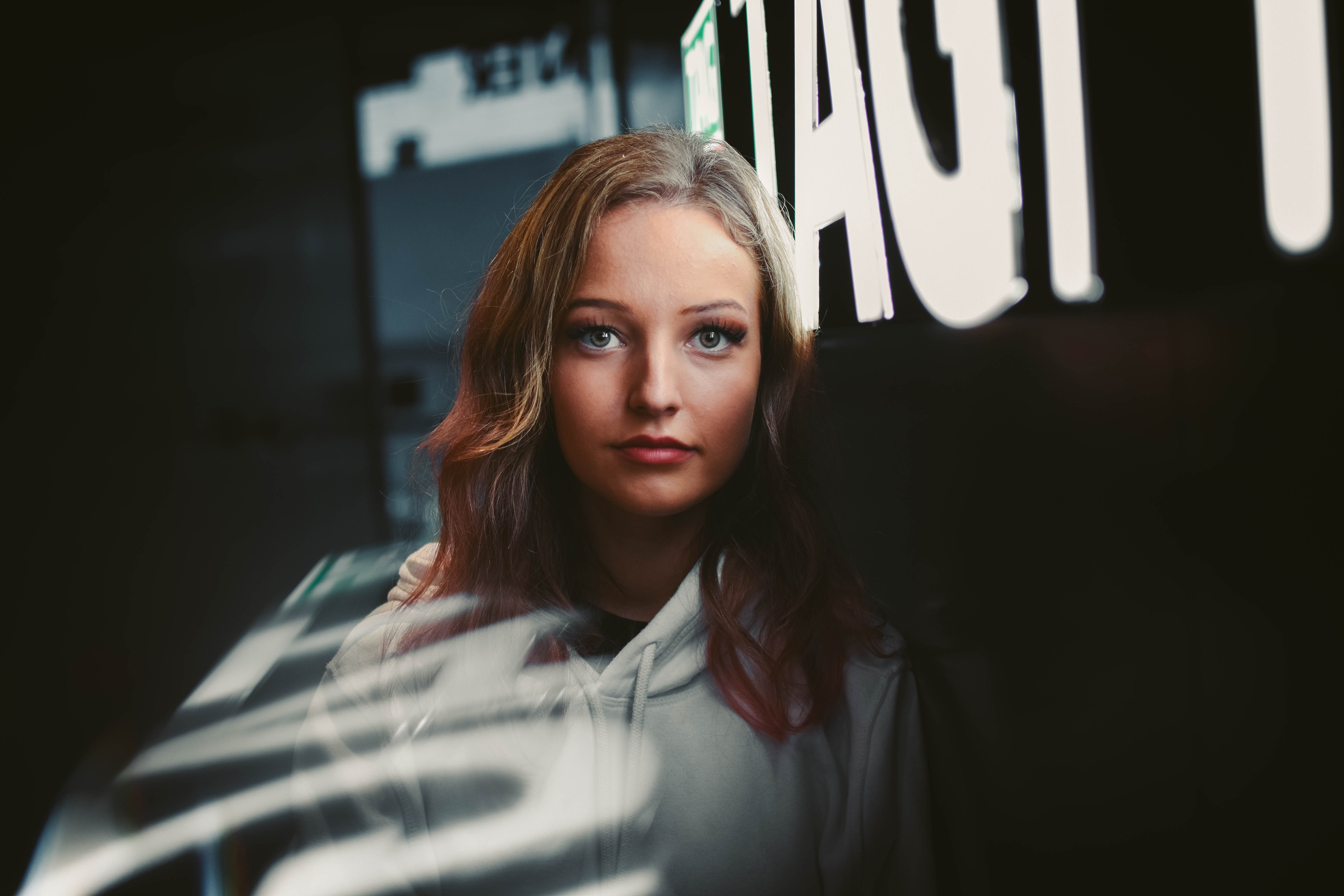 Woman in hoodie with neon lights in background HD Wallpaper