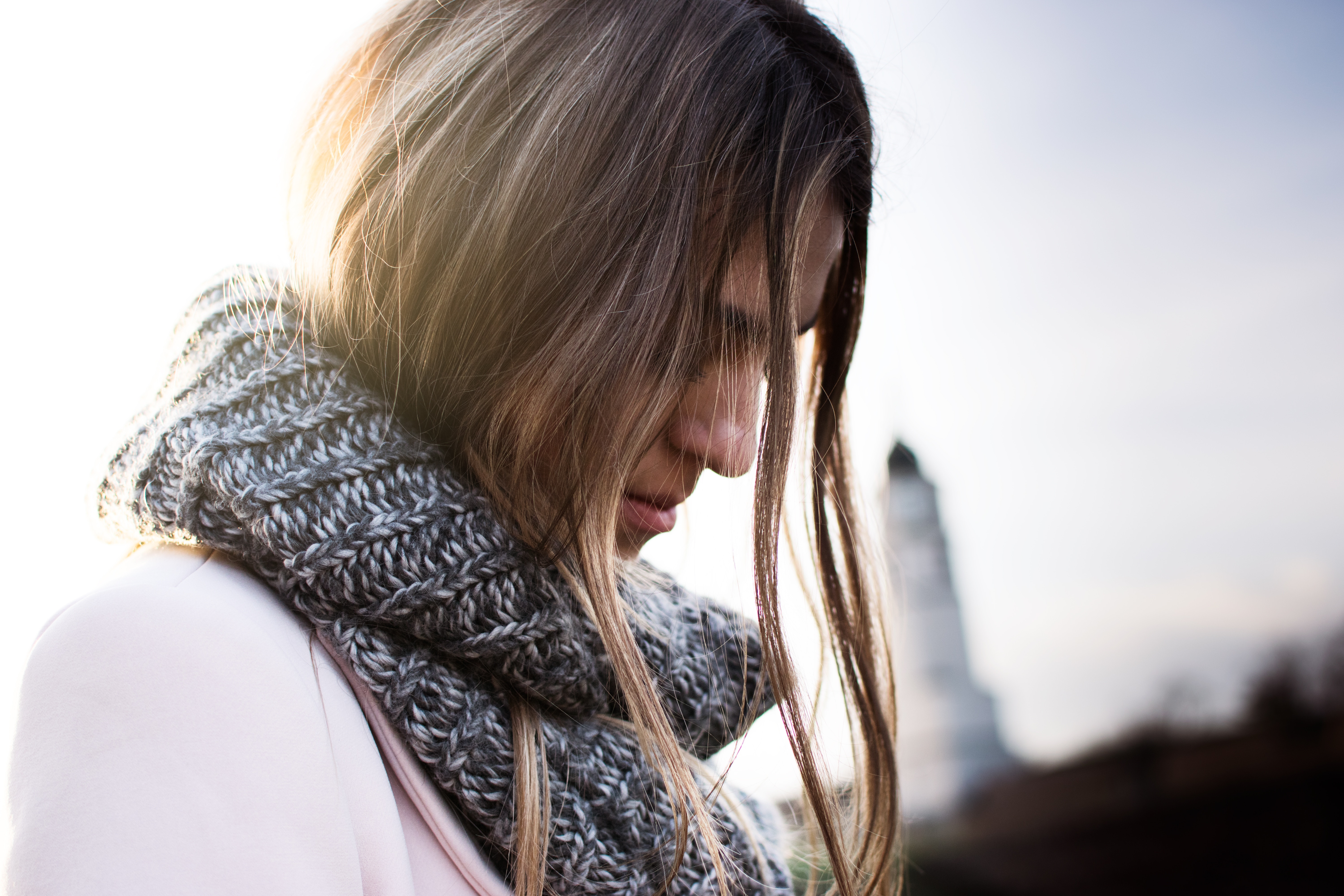 Woman with long hair wearing a scarf in the city HD Wallpaper