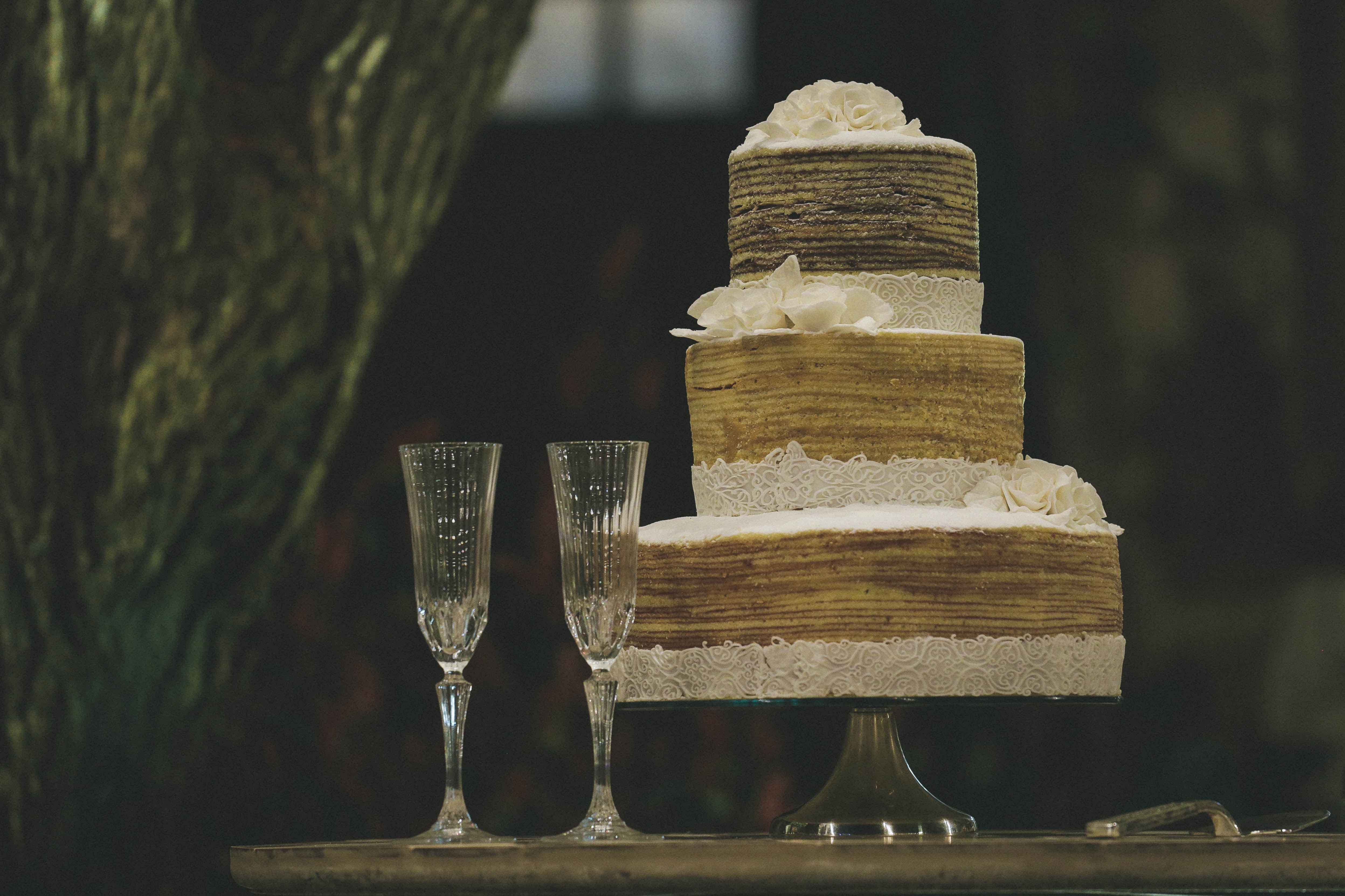 Three-tiered wedding cake with champagne flutes HD Wallpaper