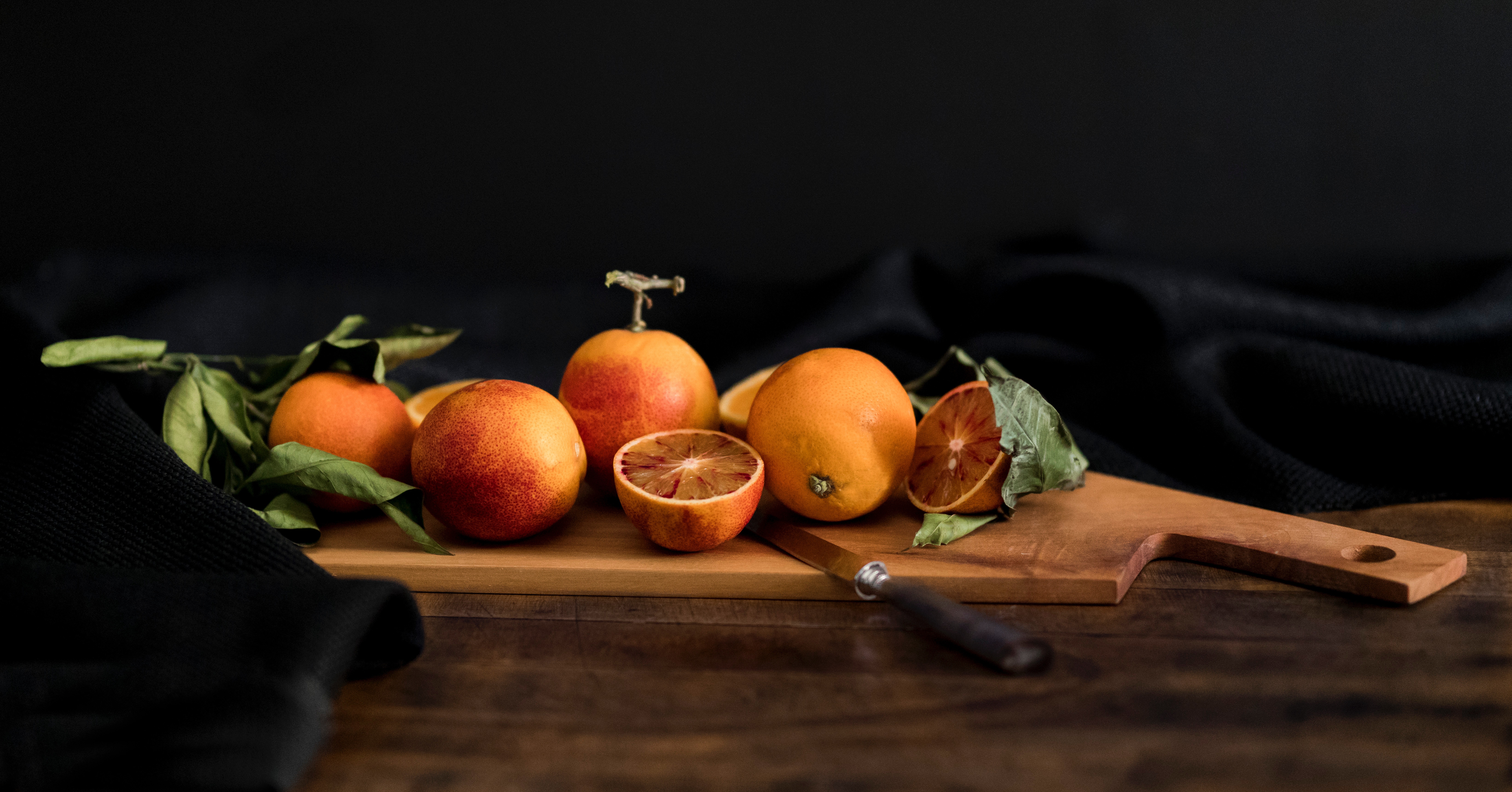 Blood oranges on a wooden chopping board with a knife HD Wallpaper