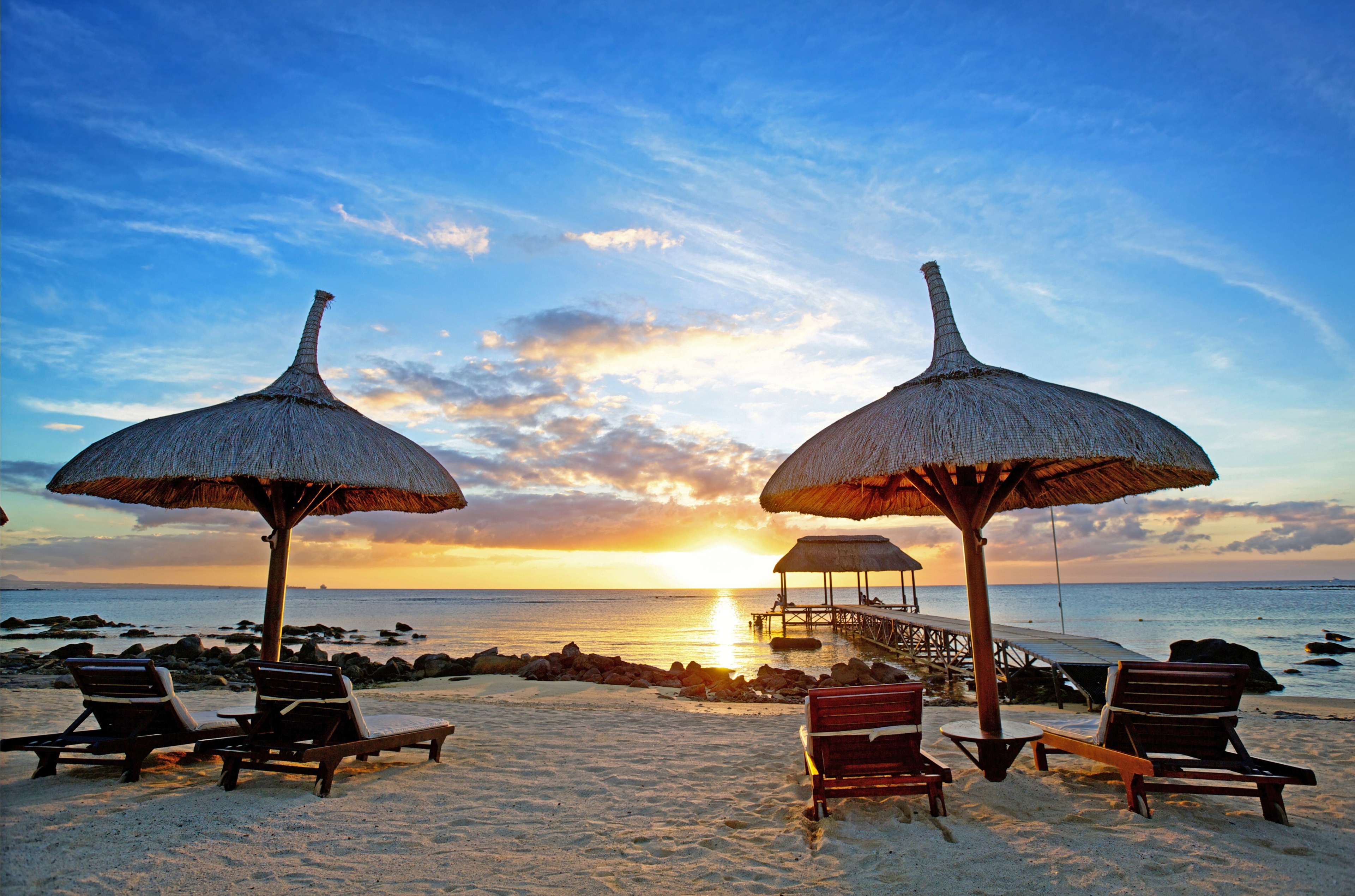 Beach umbrellas and lounge chairs at sunset in Mauritius HD Wallpaper