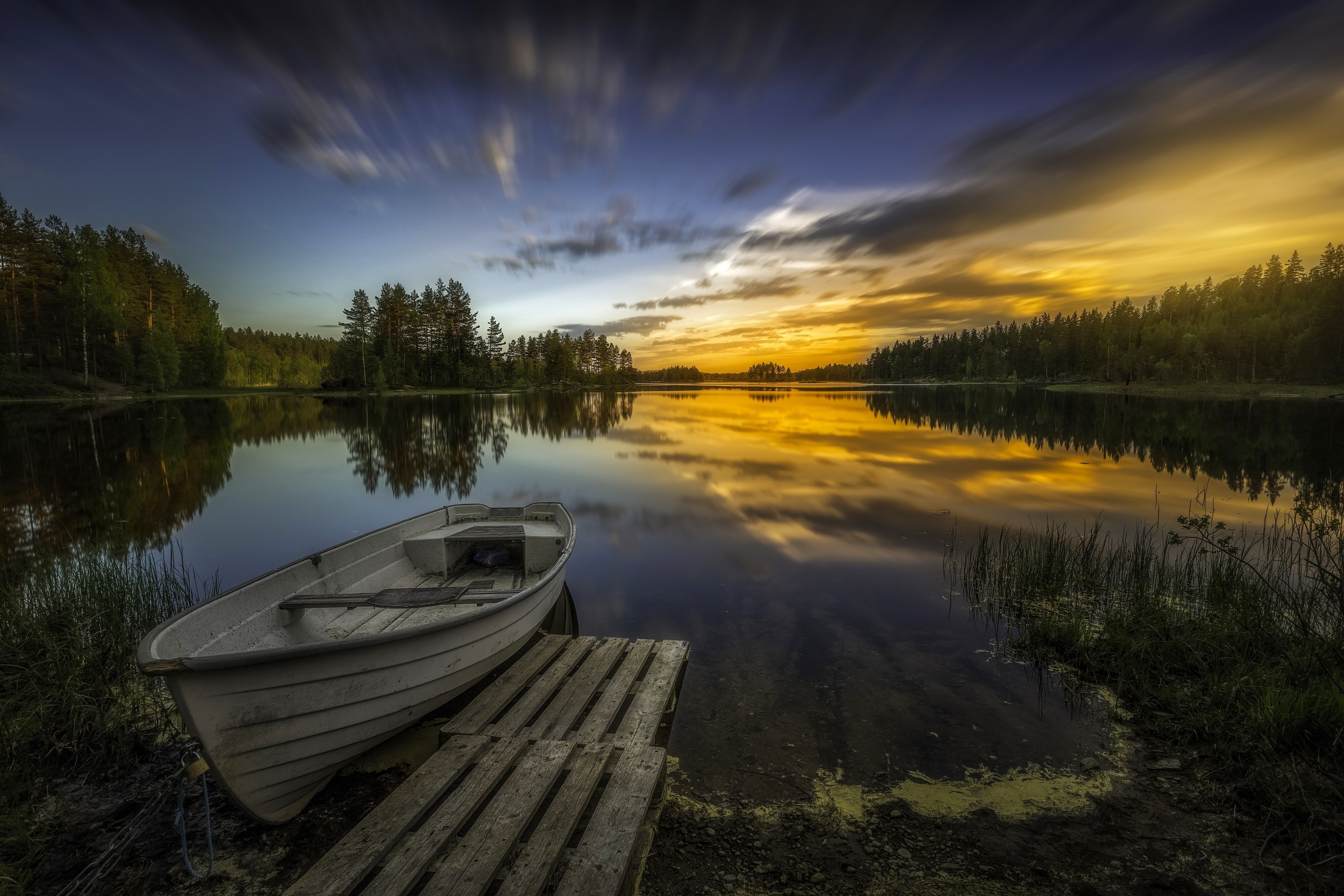 Boat docked on a lake at sunset 4K HD Wallpaper