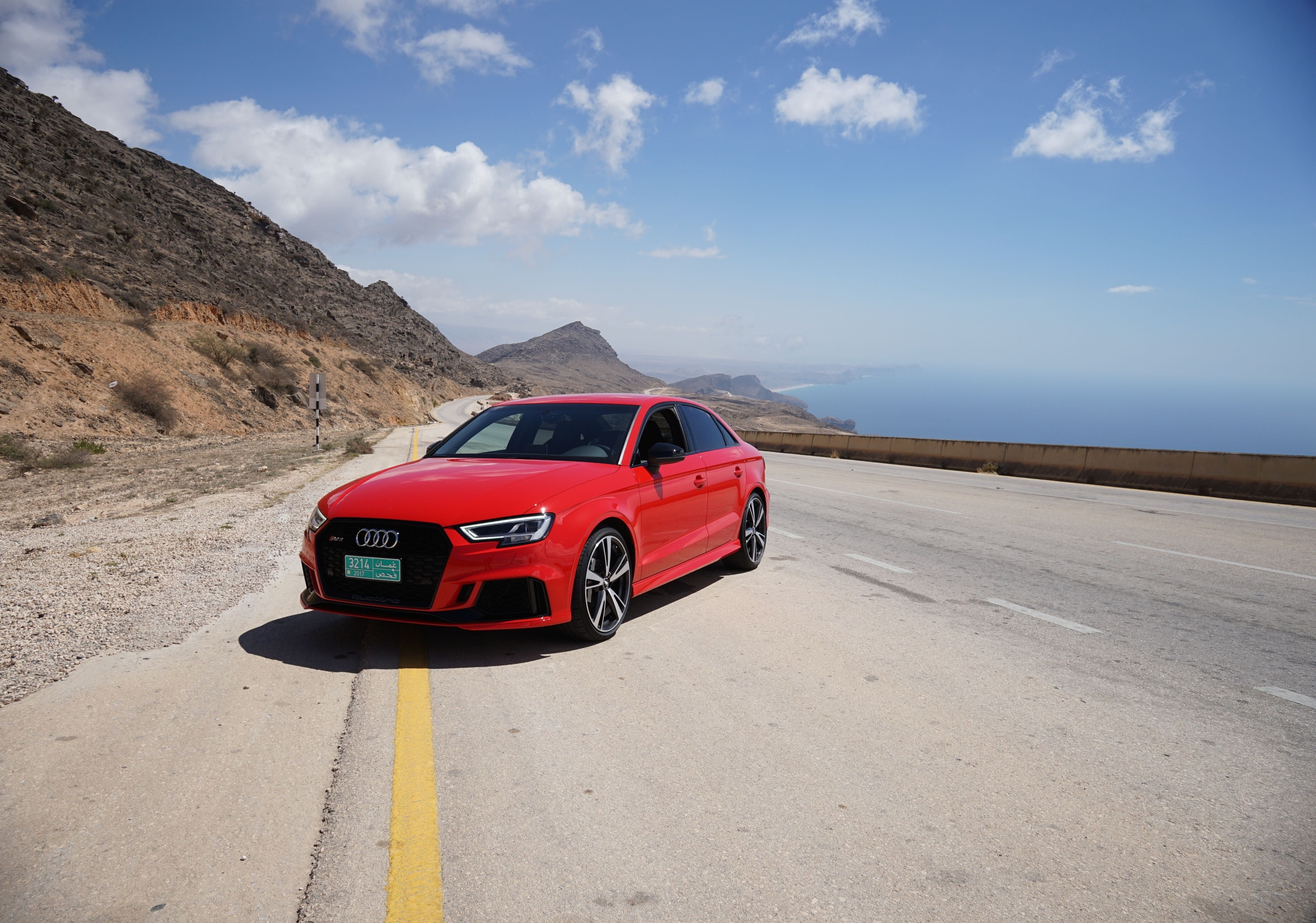Red Audi RS 3 on a coastal road HD Wallpaper