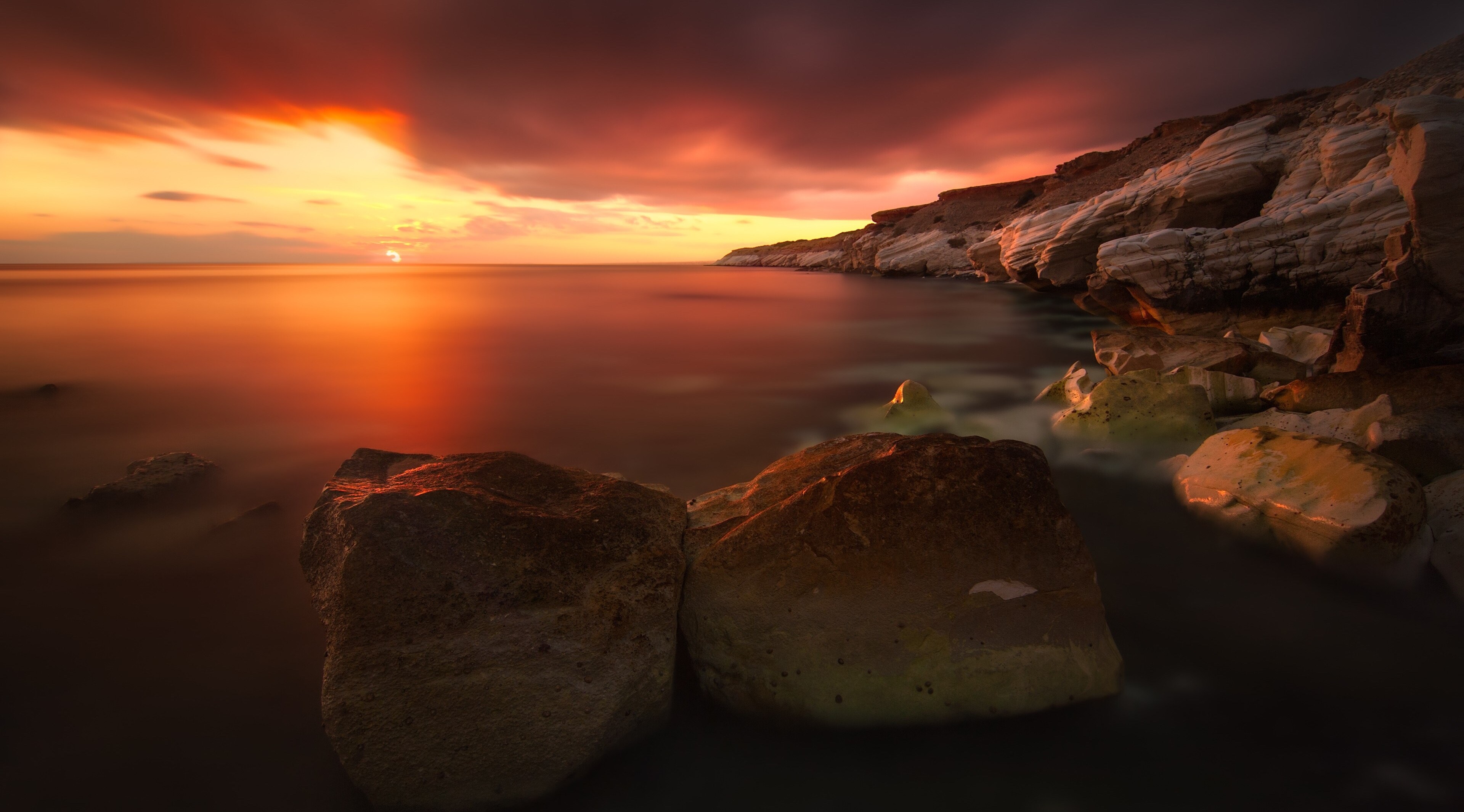 4K Sunset Over Calm Rocky Shoreline HD Wallpaper