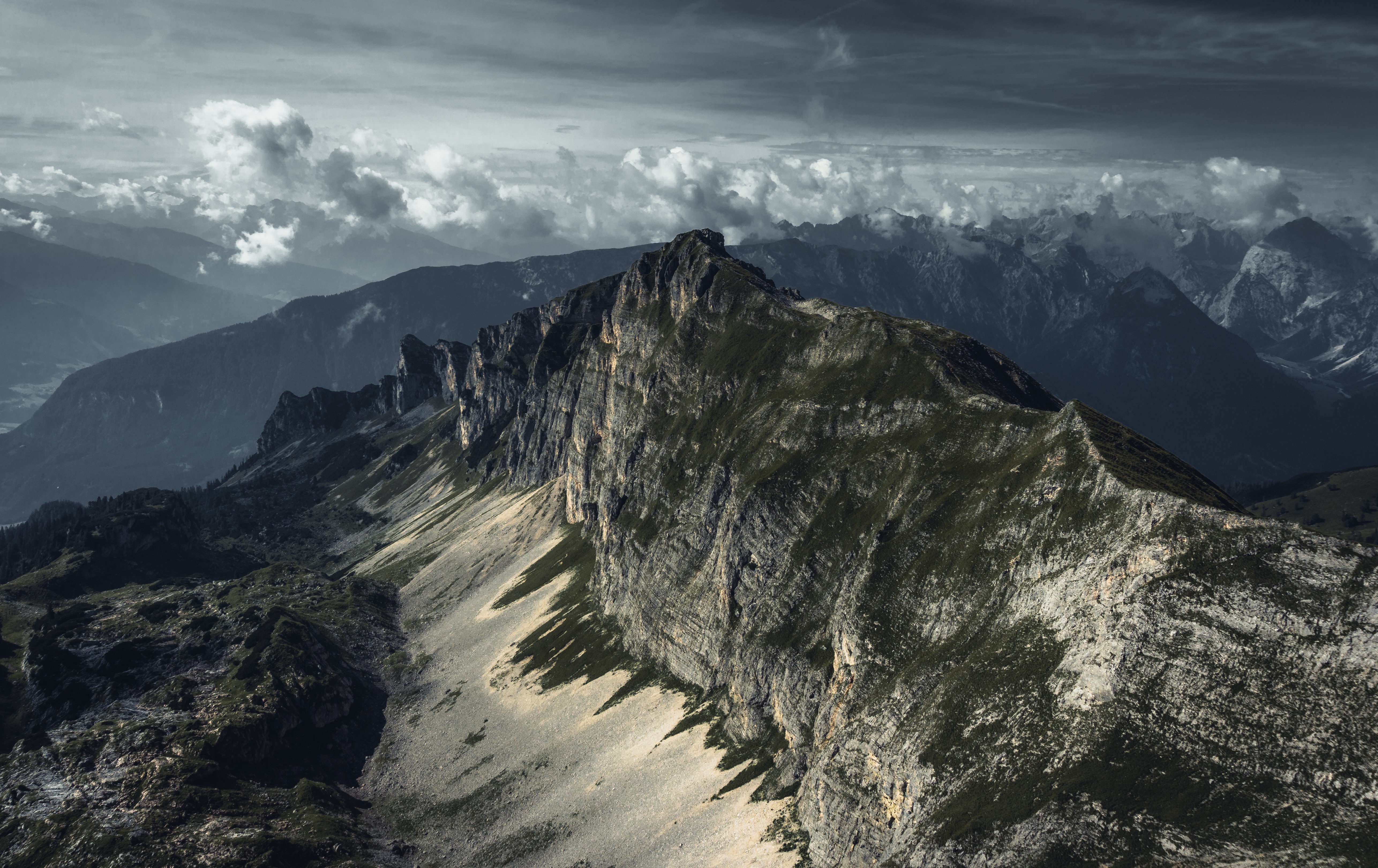 Dramatic mountain range under cloudy sky HD Wallpaper