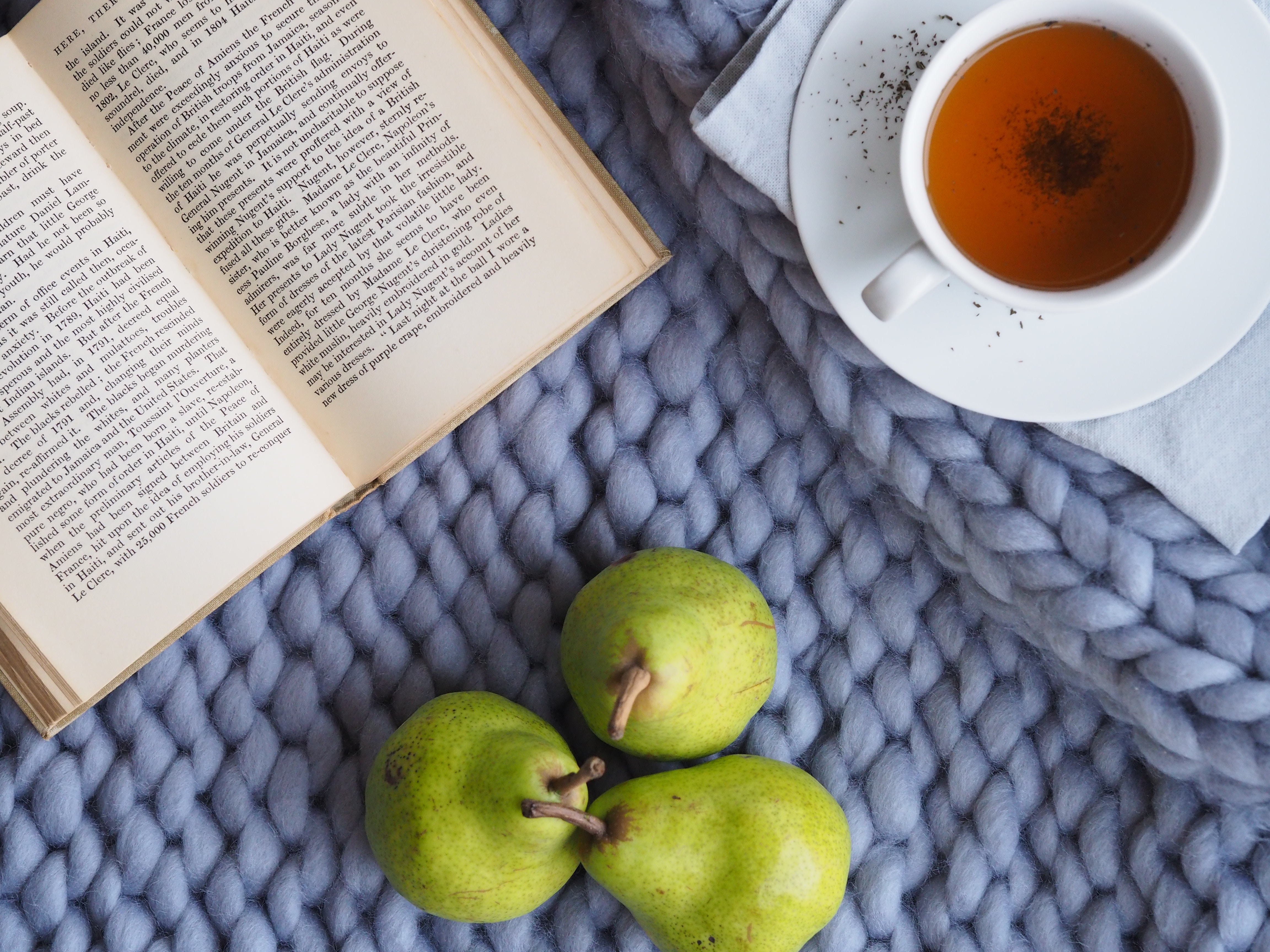 Book, tea, and pears on a knitted blanket HD Wallpaper