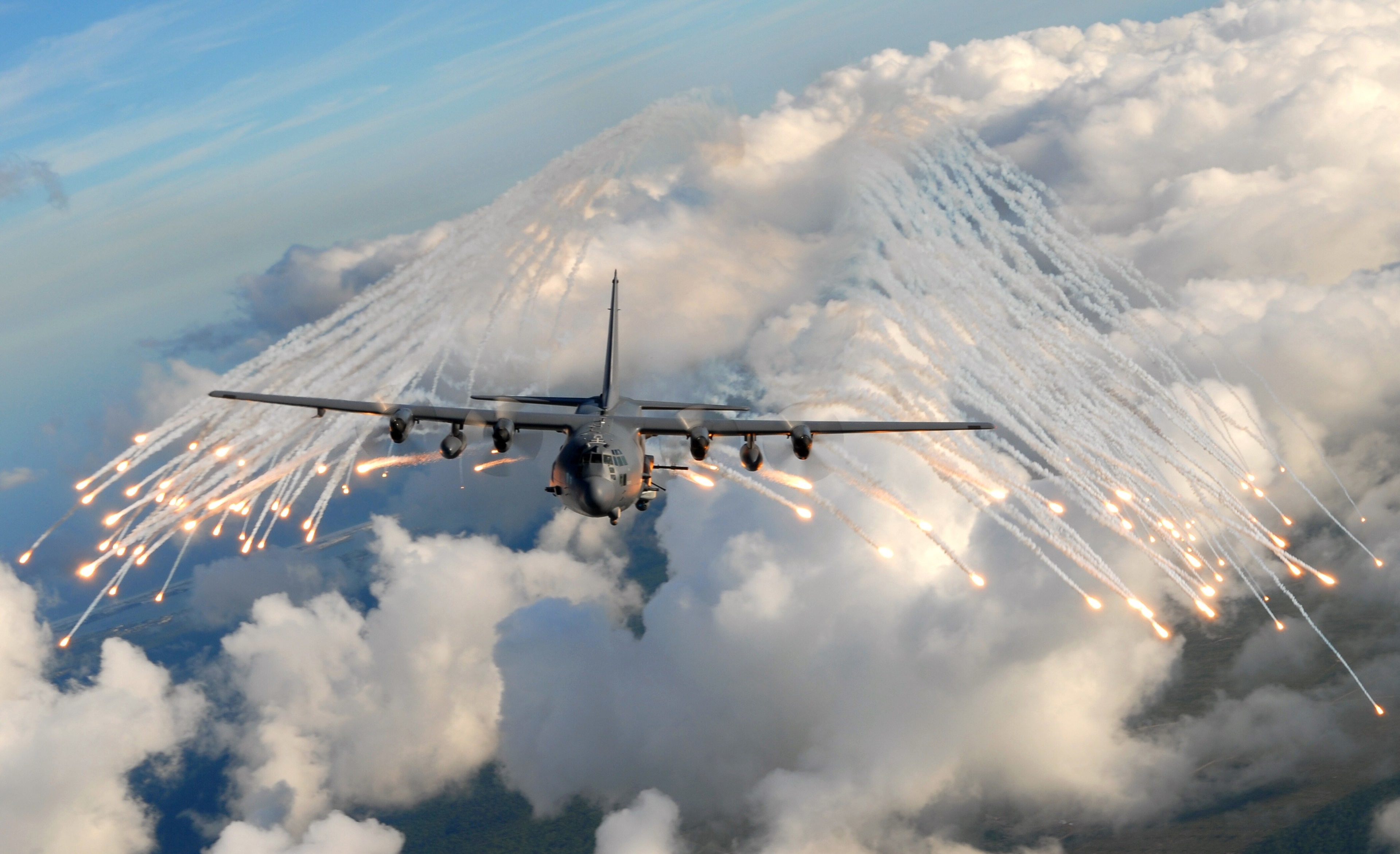 AC-130 Aircraft Deploys Flares Over Clouds HD Wallpaper