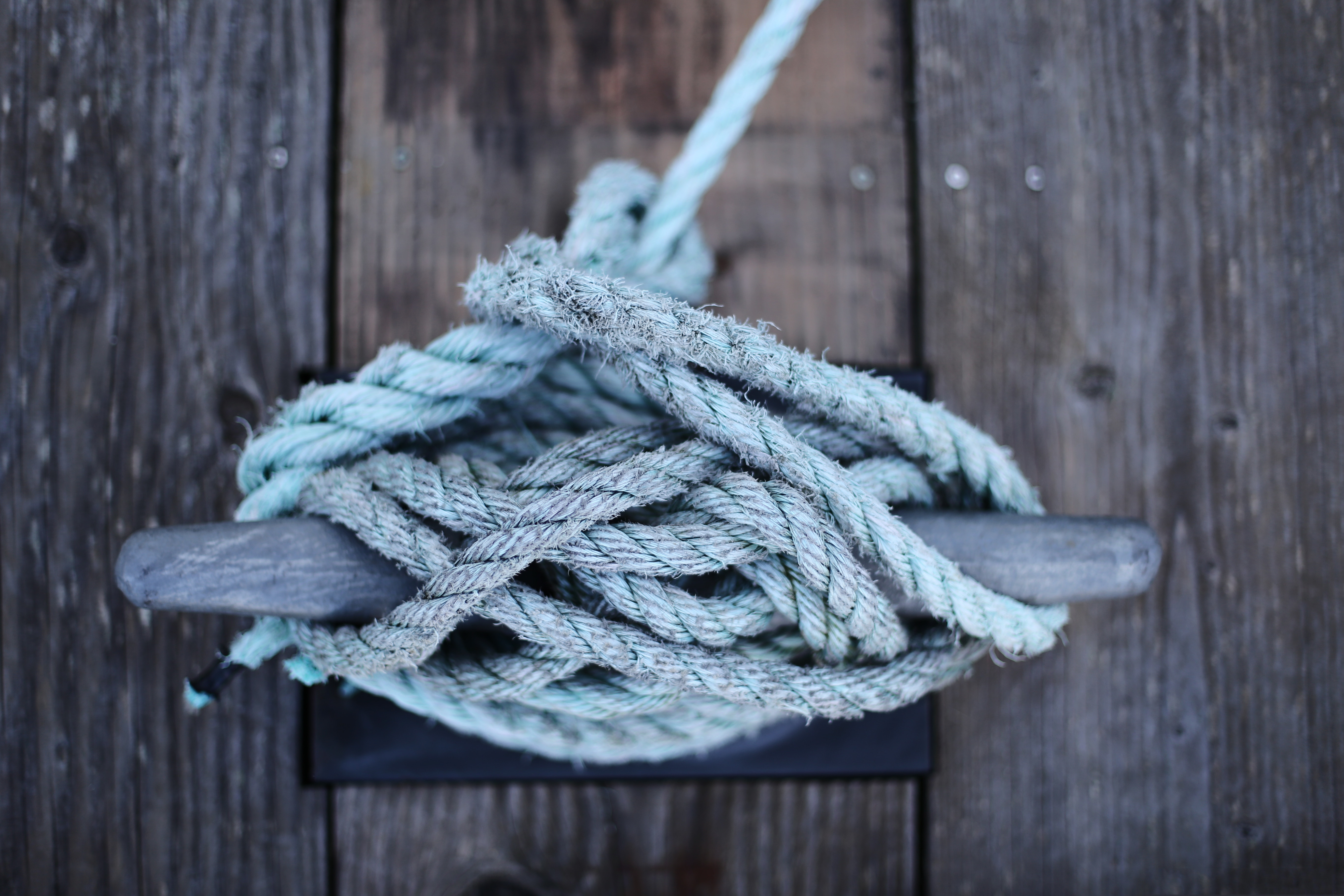 Rope tied to a cleat on a wooden dock HD Wallpaper