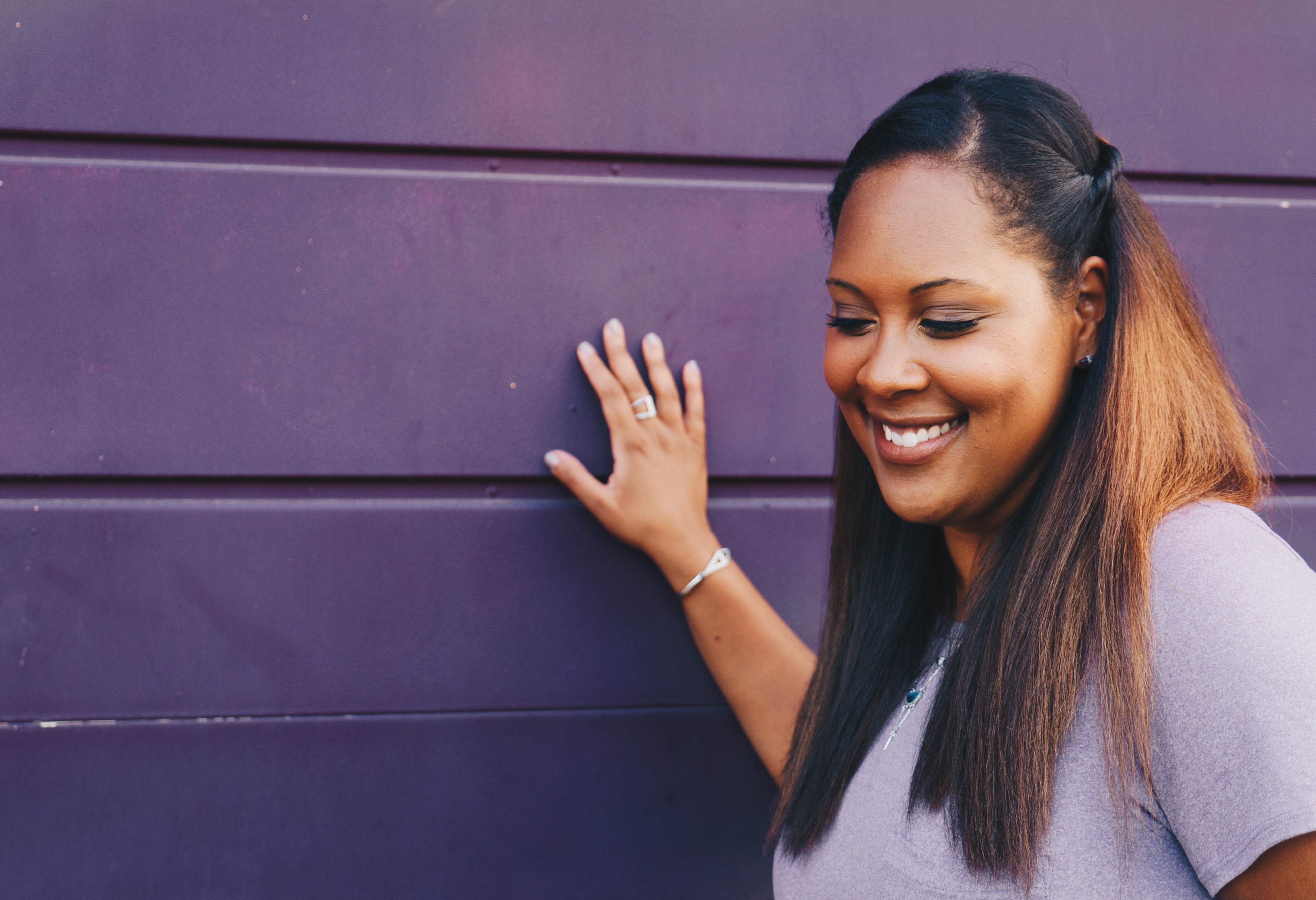 African American woman smiling against a purple wall HD Wallpaper