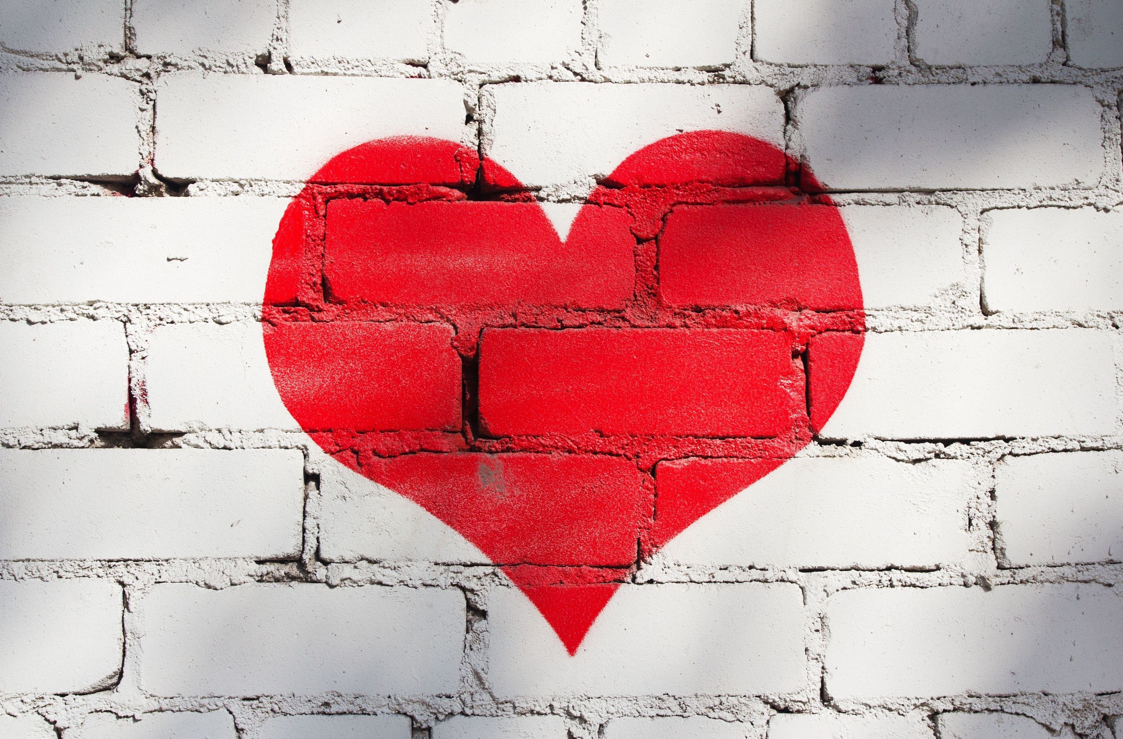 Red heart graffiti on white brick wall HD Wallpaper