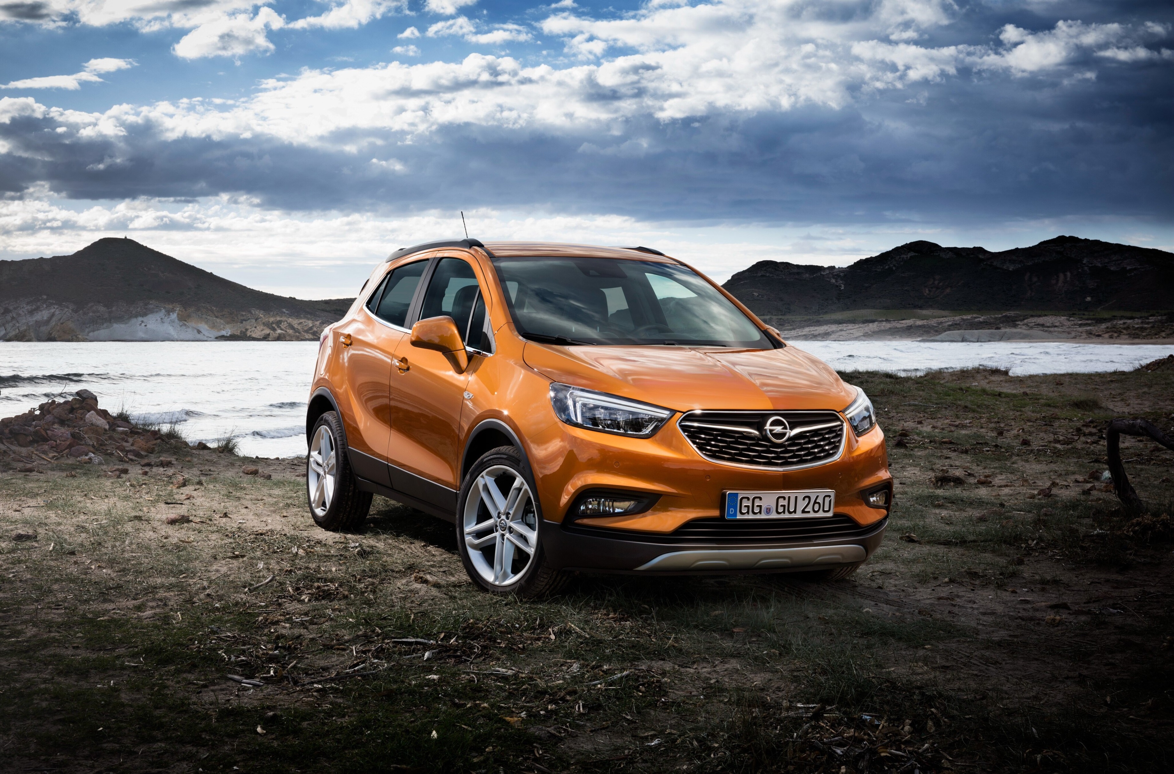 Orange Opel Mokka X parked by the sea HD Wallpaper
