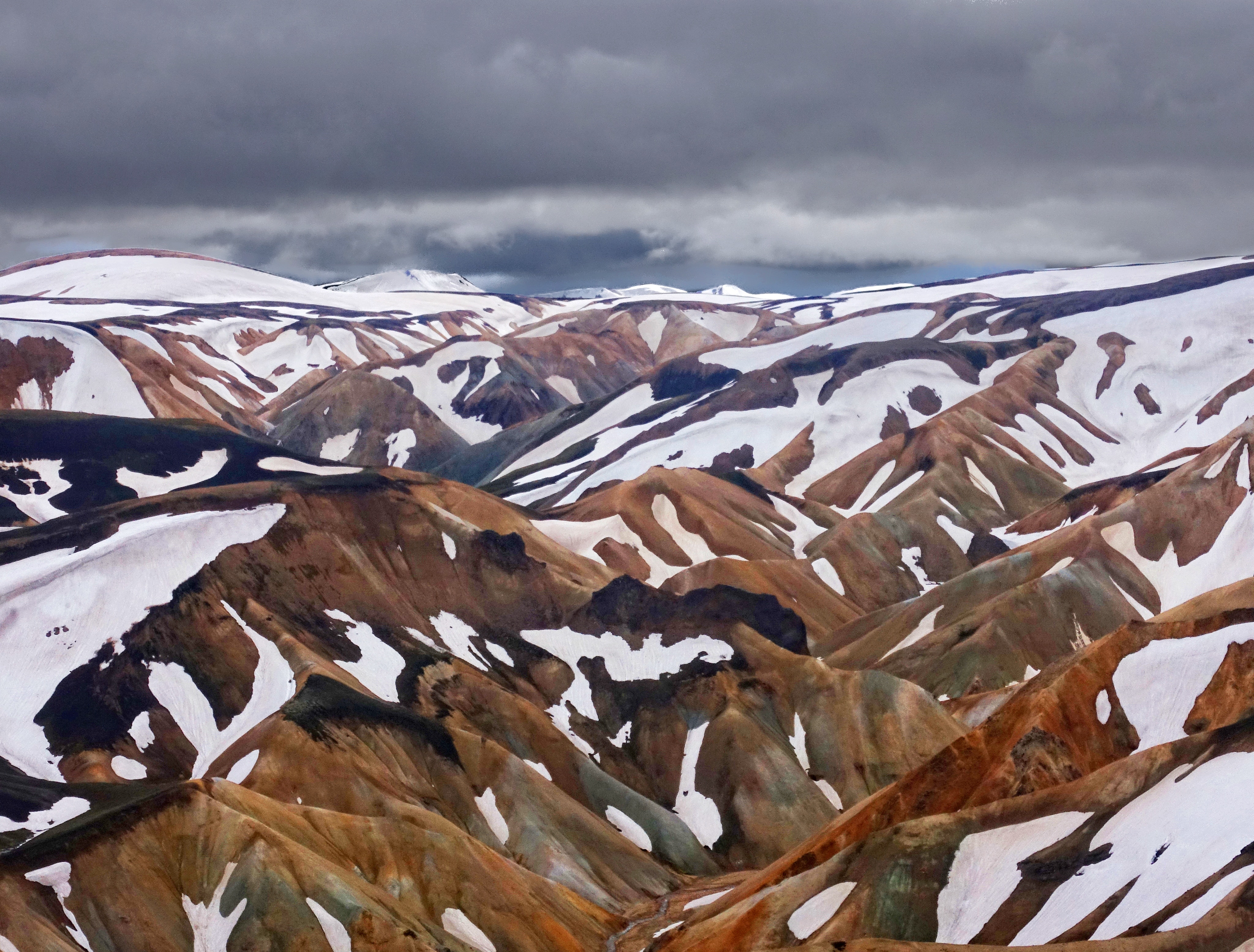 Snow-covered mountains in Iceland under a cloudy sky HD Wallpaper