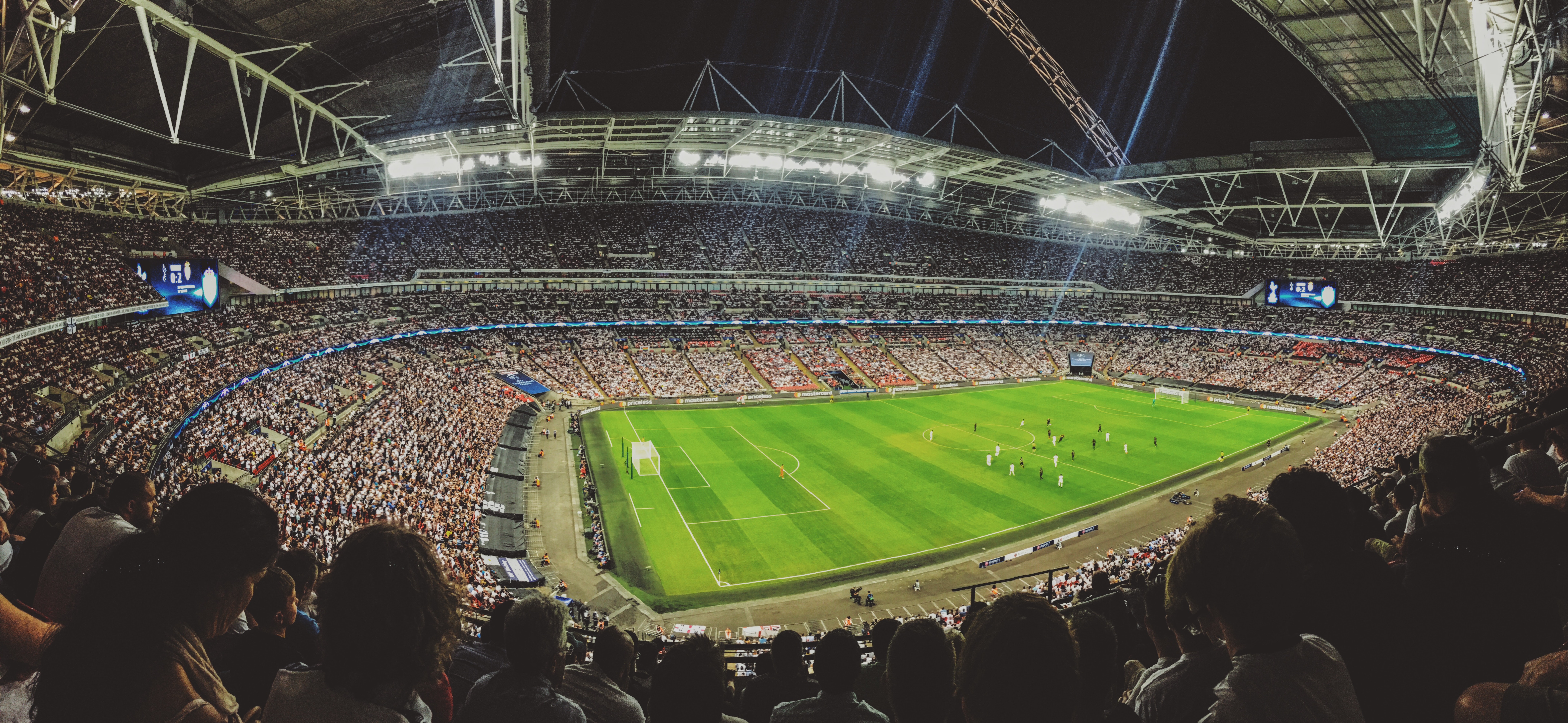 Soccer match in a packed stadium at night HD Wallpaper