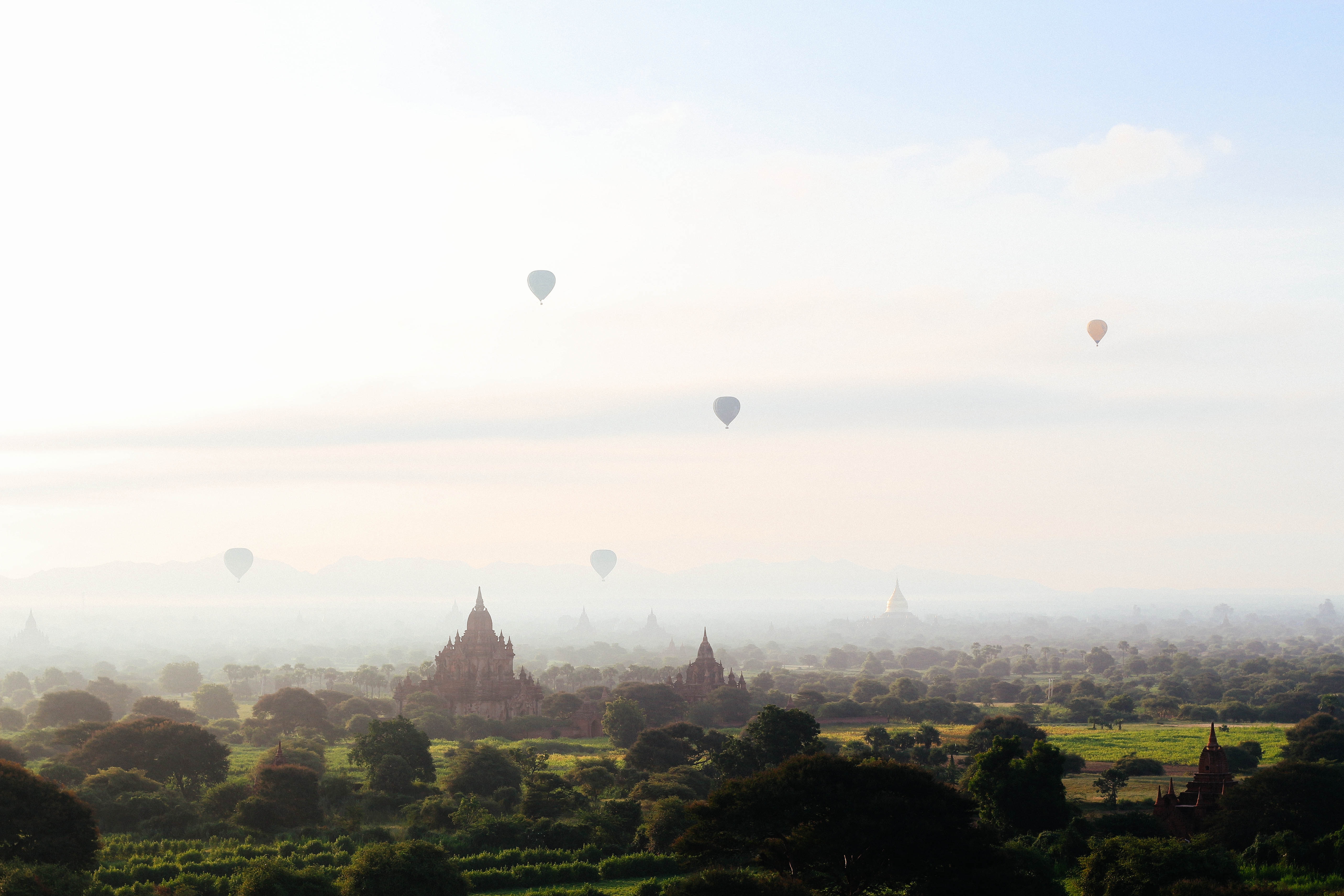 Hot air balloons over ancient temples in the fog HD Wallpaper