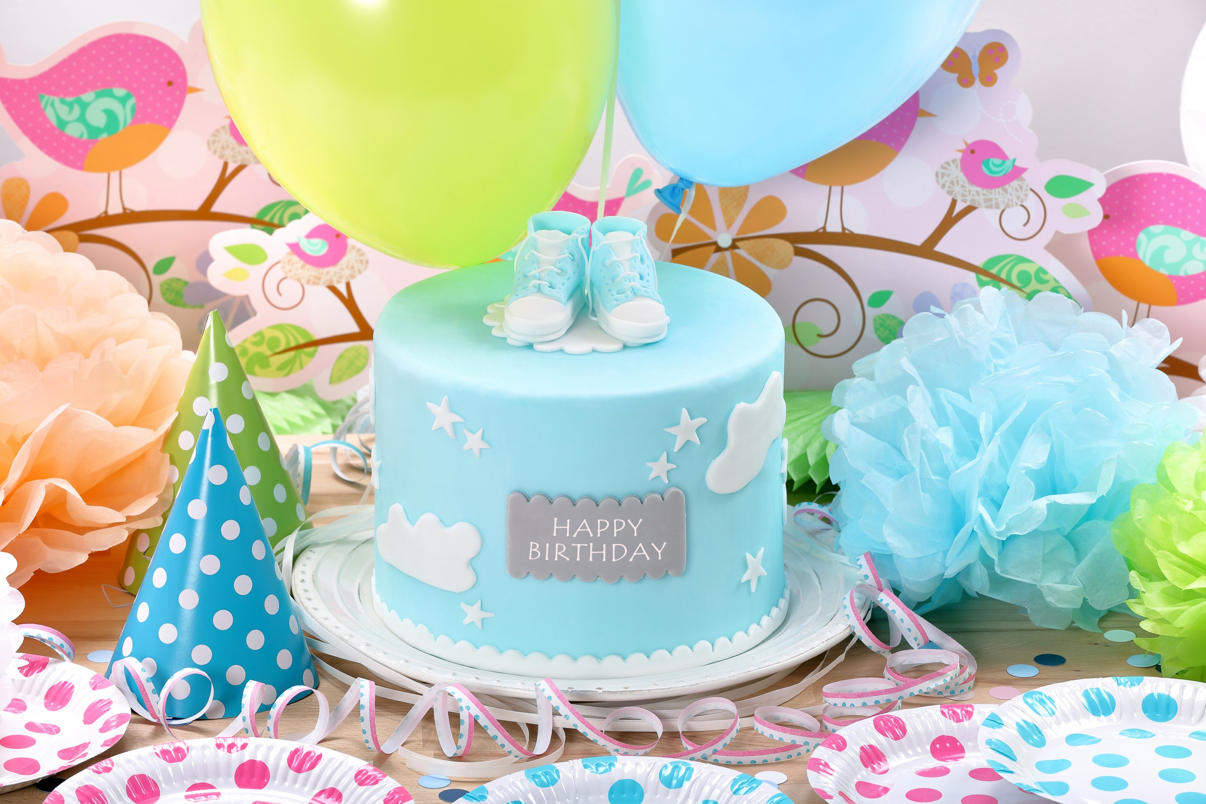 Birthday cake with baby shoes and party decorations HD Wallpaper