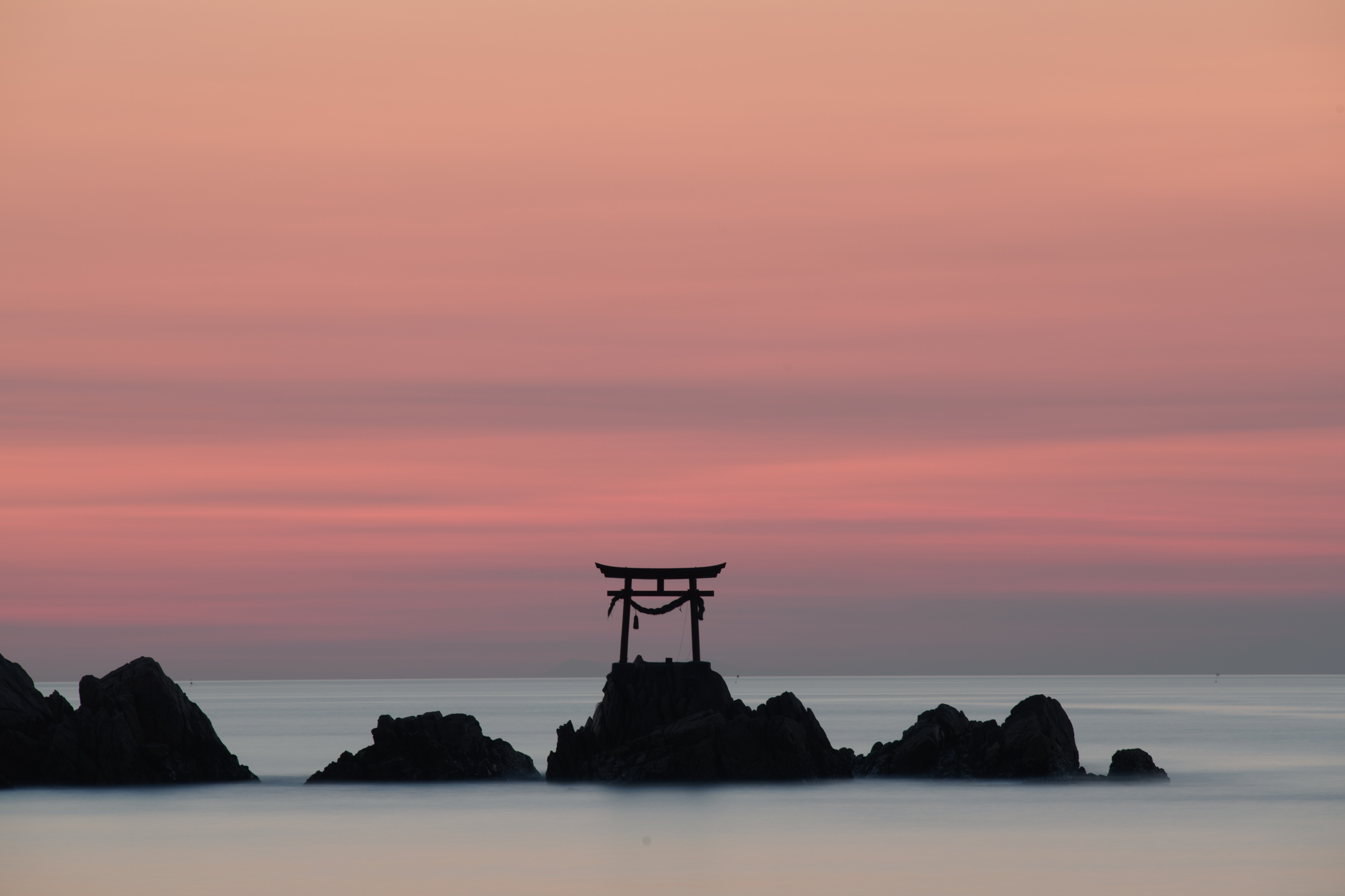 Torii gate on rocks at sunrise over the ocean HD Wallpaper