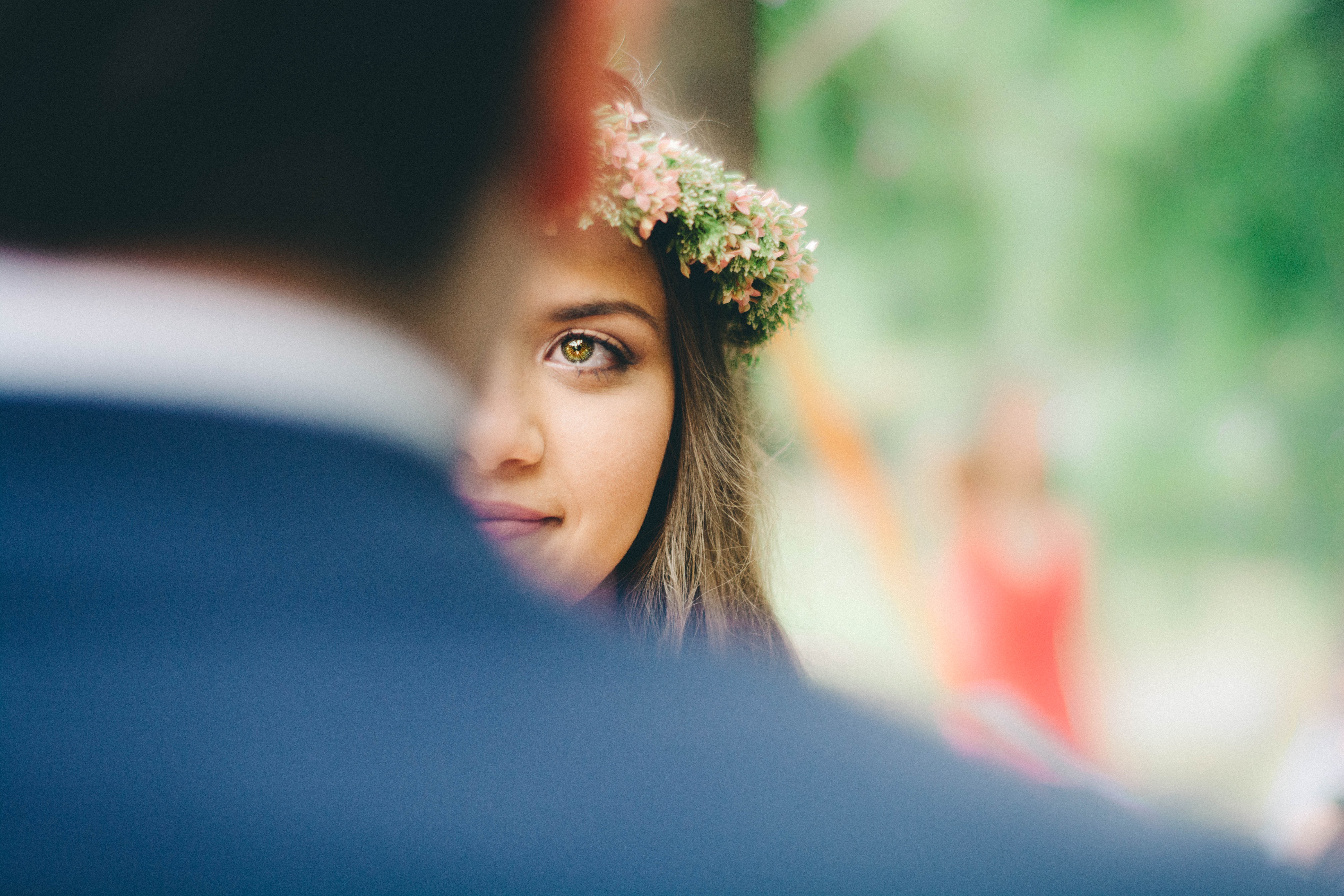 Woman with flower crown looking over man's shoulder HD Wallpaper