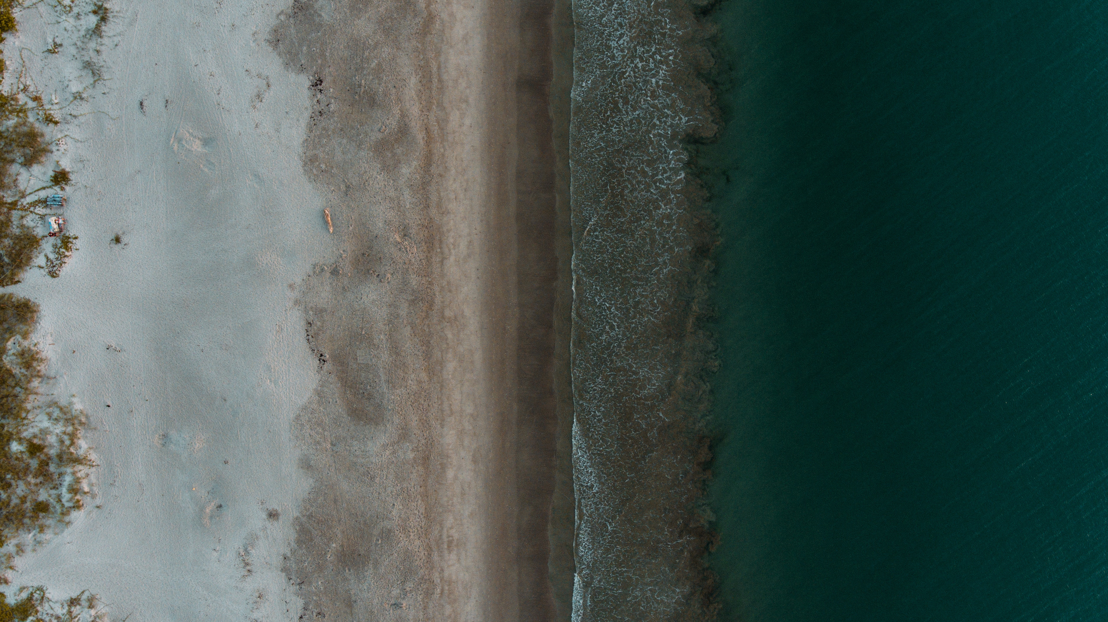 Aerial view of a sandy beach and ocean waves HD Wallpaper