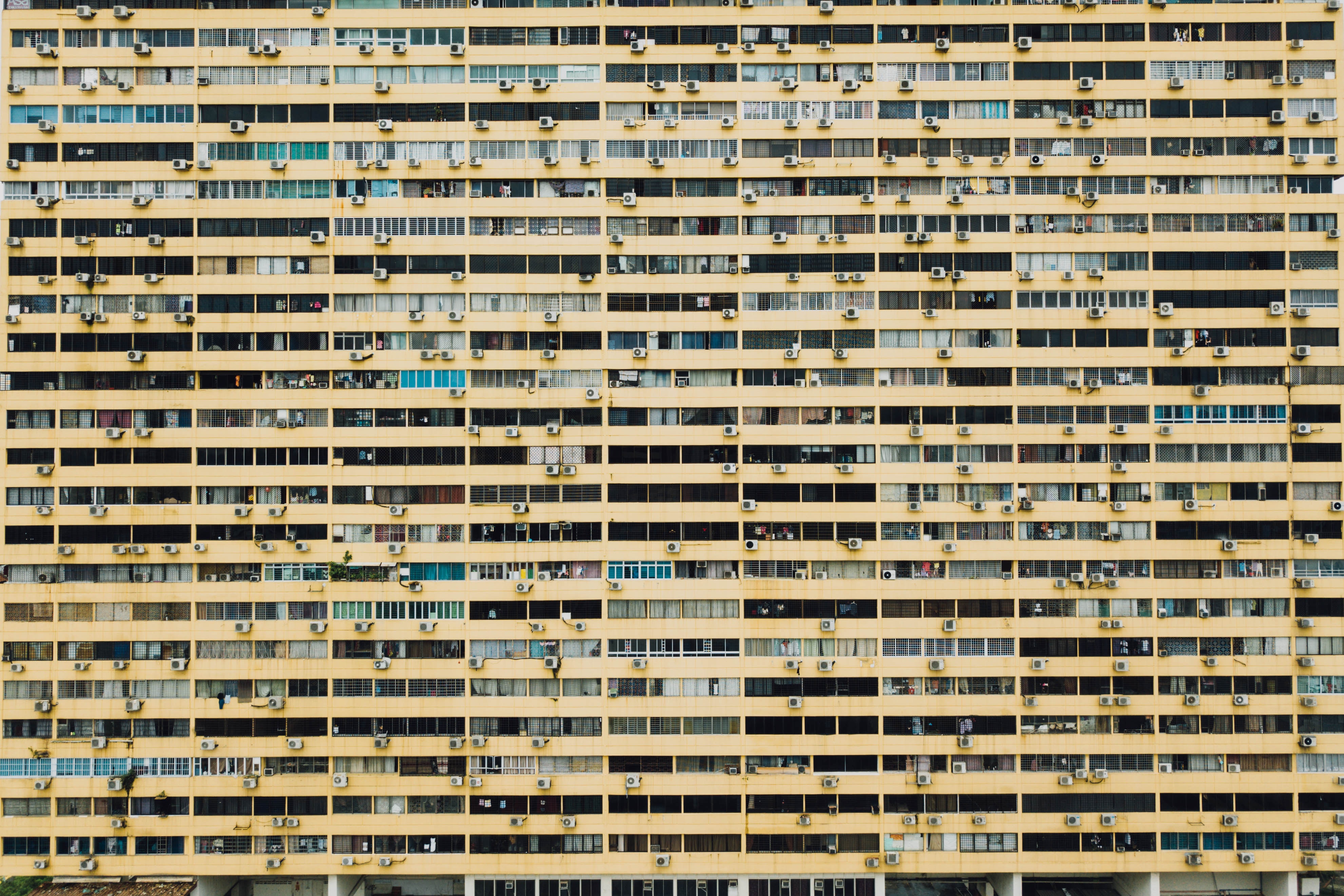 Yellow apartment building with many windows and balconies HD Wallpaper