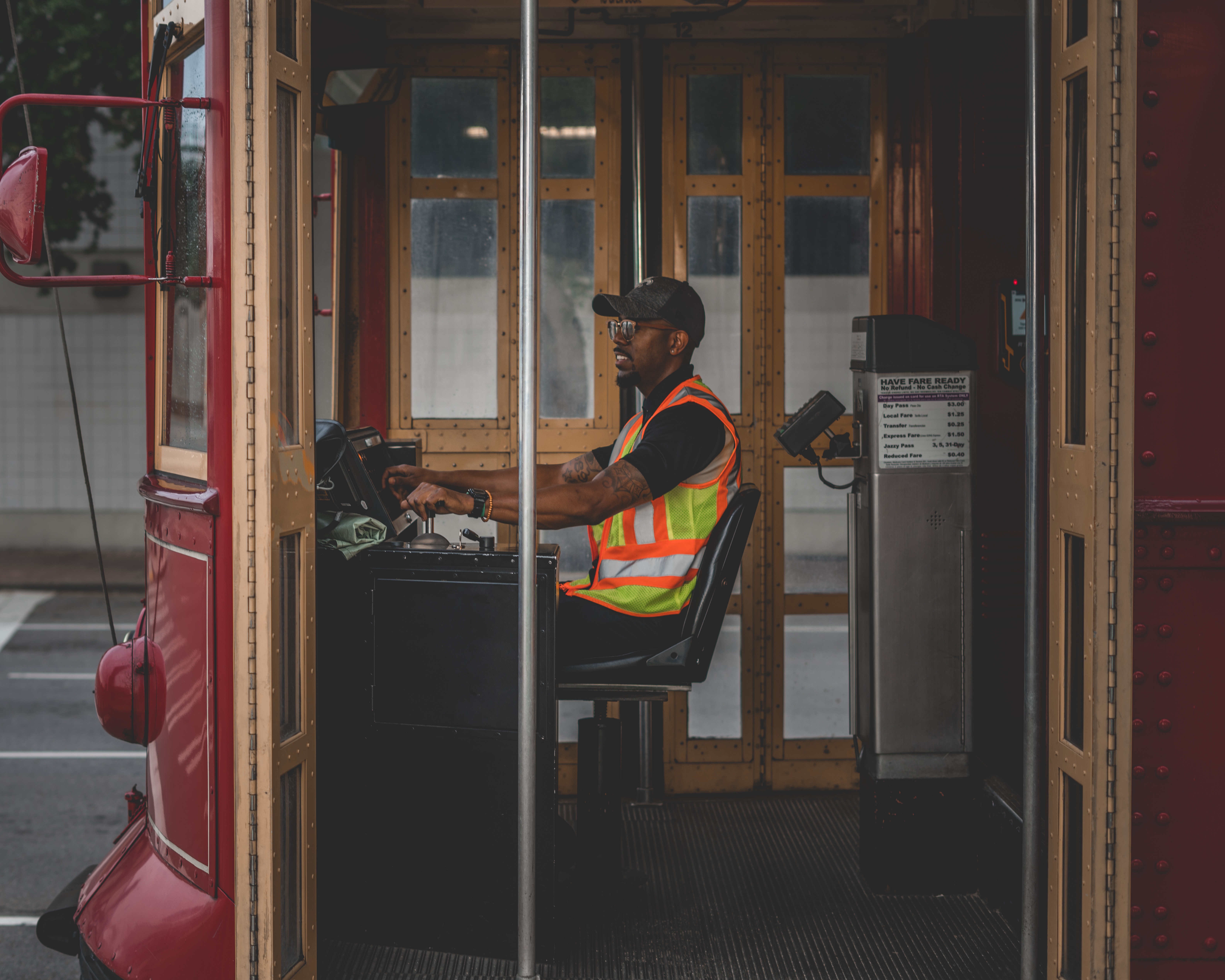 Man driving a red trolley wearing a reflective vest HD Wallpaper